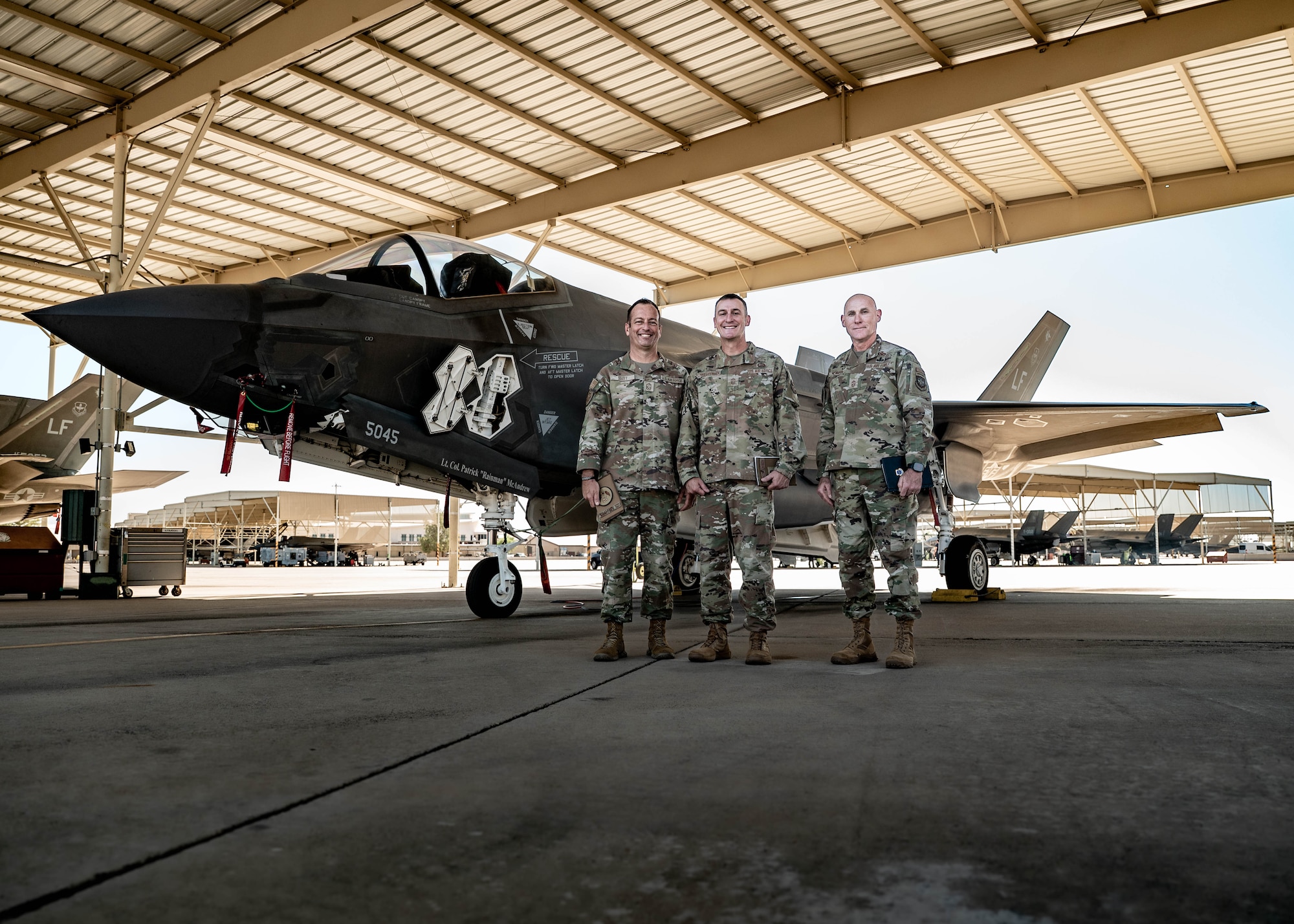 U.S. Air Force Chief Master Sgts. Keith Scott (left), 19th Air Force command chief, Nathan Chrestensen (middle), 56th Fighter Wing command chief, and Jamie Newman (right), Headquarters Air Mobility Command command chief, pose in front of an F-35A Lightning II