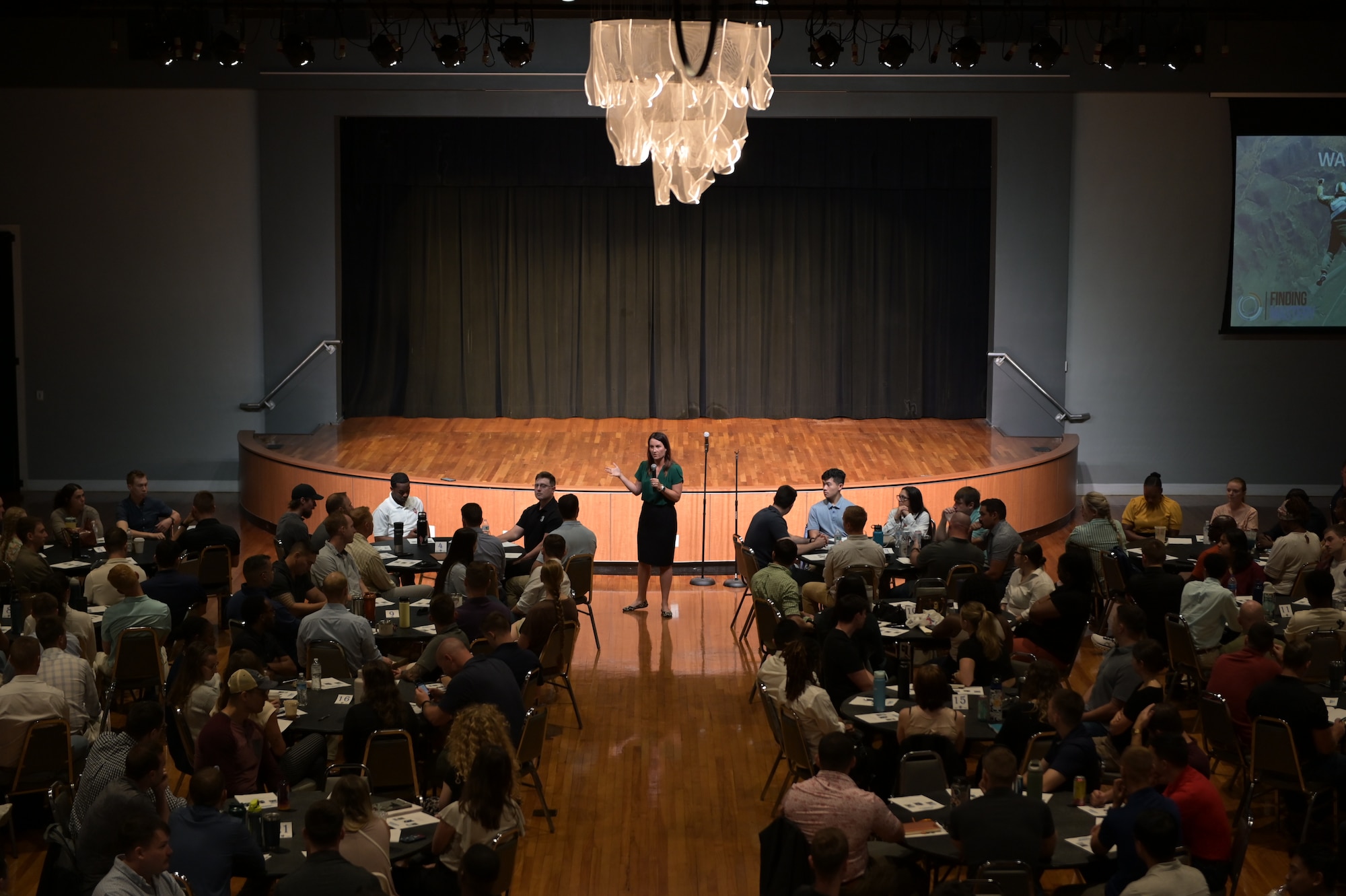 Retired U.S. Air Force Lt. Col. Jannell MacAulay, cofounder of Warrior’s Edge, walks through the center of a large conference room surrounded by students.