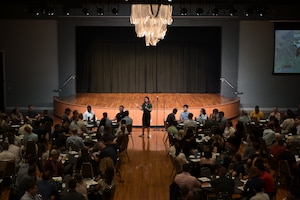 Retired U.S. Air Force Lt. Col. Jannell MacAulay, cofounder of Warrior’s Edge, walks through the center of a large conference room surrounded by students.