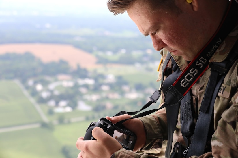 U.S. Soldiers with the 109th Mobile Public Affairs Detachment, 213th Readiness Support Group, Pennsylvania Army National Guard, fly in a UH-60 Black Hawk during the unit’s coverage of aviation operations at Muir Army Heliport on Fort Indiantown Gap, Pennsylvania, July 16, 2025. The operation helped hone the Soldiers' skill in photography and videography as part of their public affairs mission. (U.S. Army National Guard photo by Spc. Annie M. Riley.)