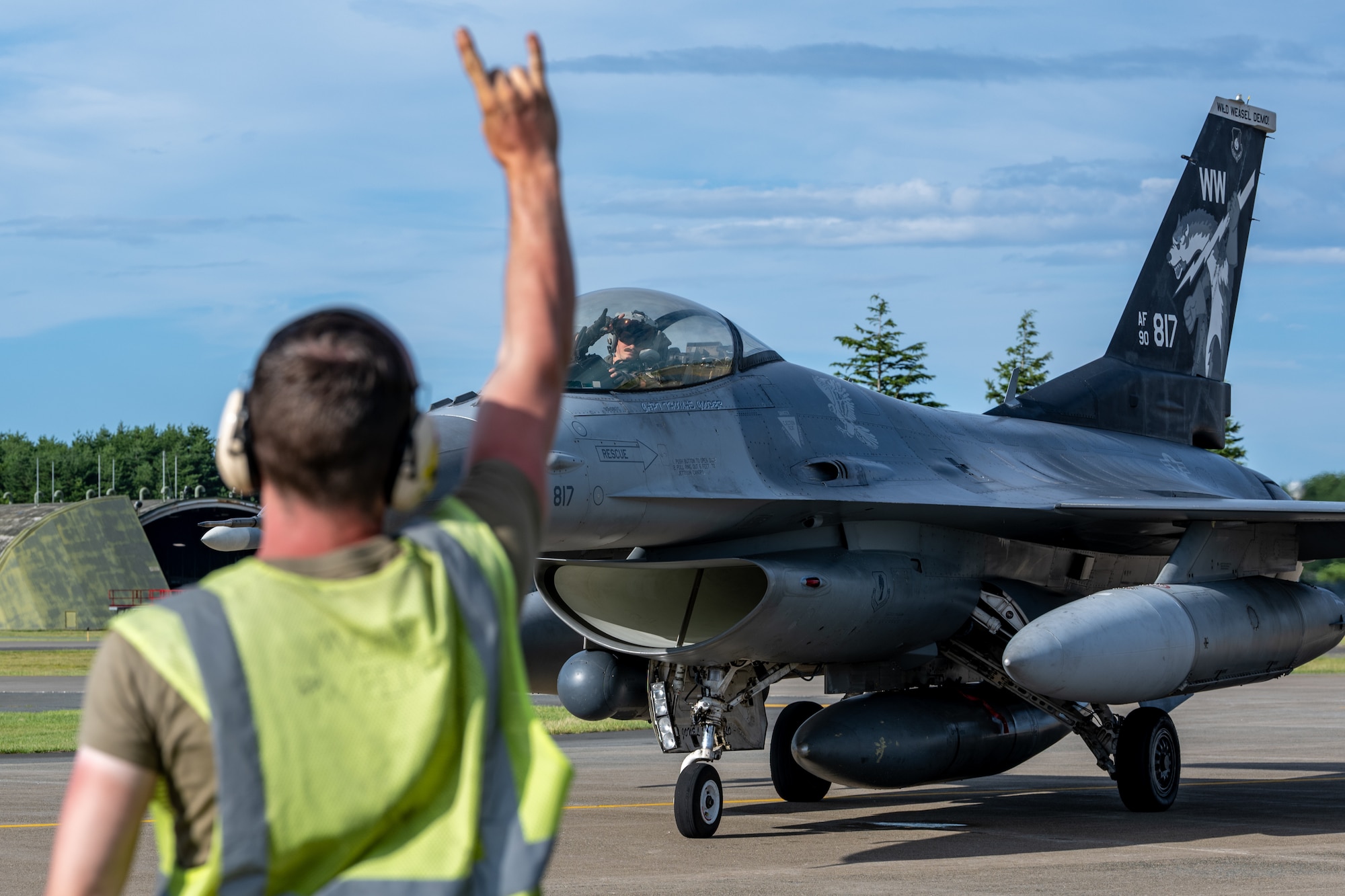 U.S. Air Force Capt. Eric Murray, 14th Fighter Squadron F-16 Fighting Falcon pilot, responds with a “Samurai Wood” hand sign to a 14th Fighter Generation Squadron Airman  during exercise Resolute Force Pacific 2025