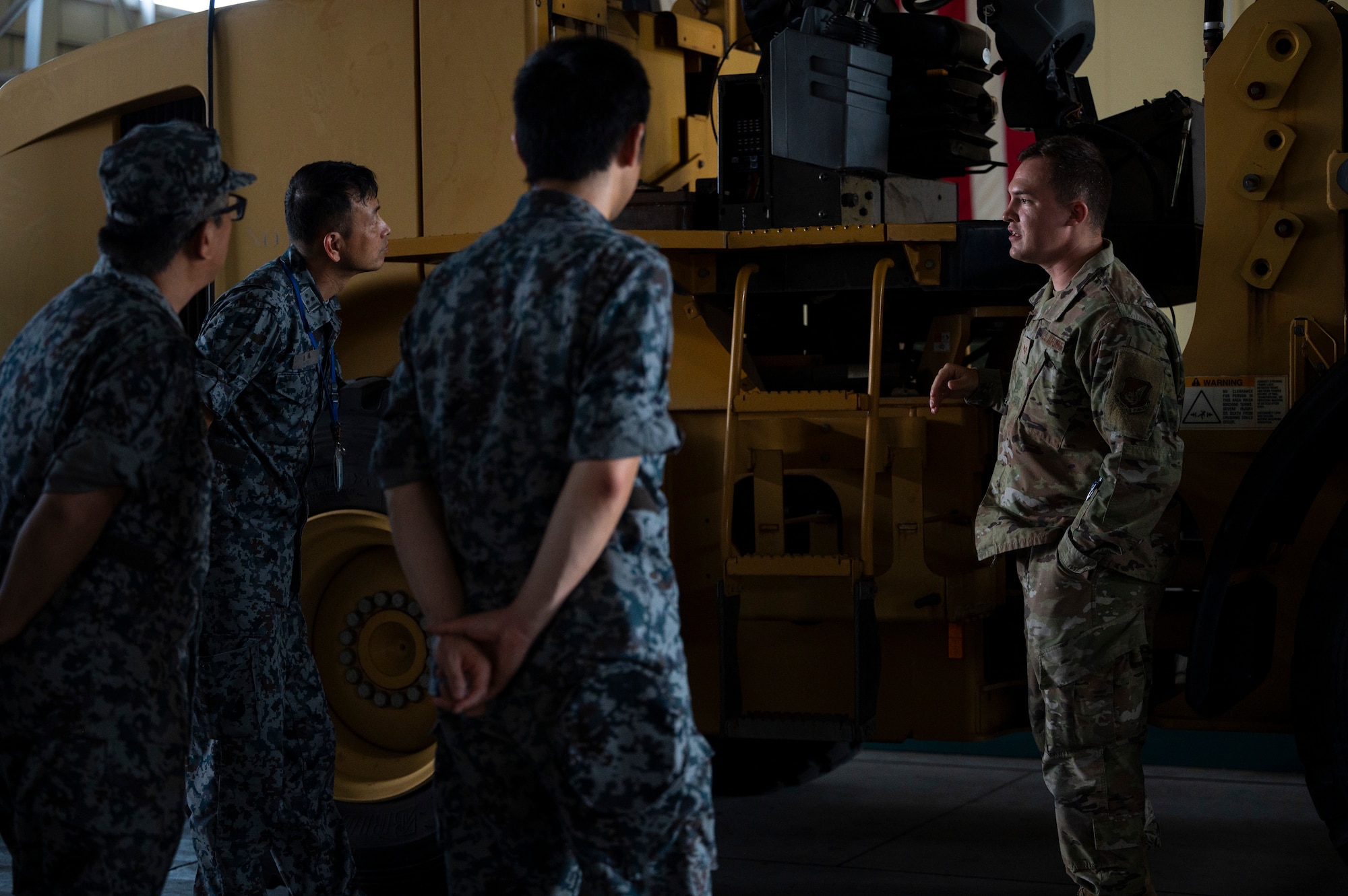A U.S. military member speaks to three Japan Air Self-Defense Force members.