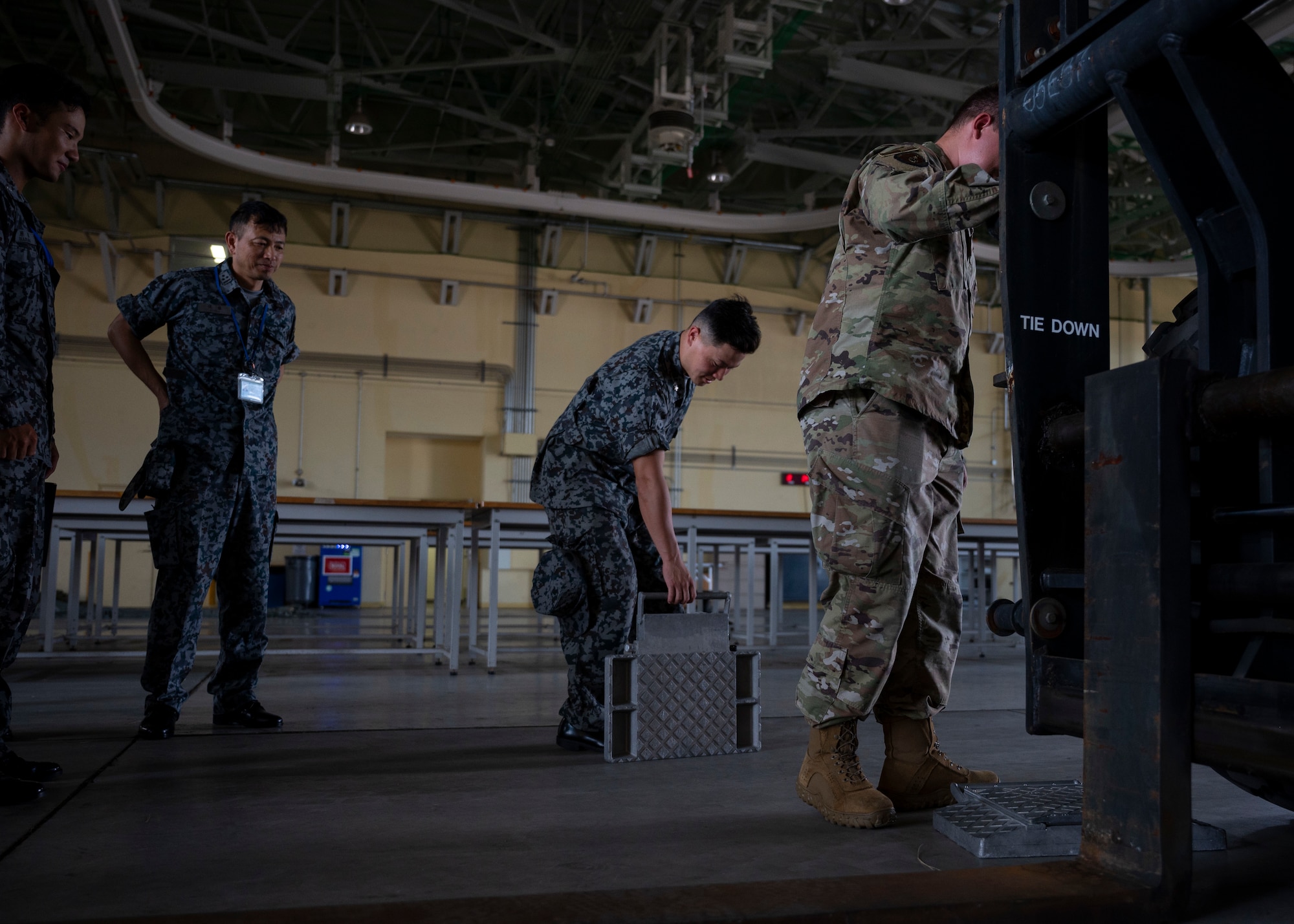 A Japan Air Self-Defense Force member lifts a metal scale.