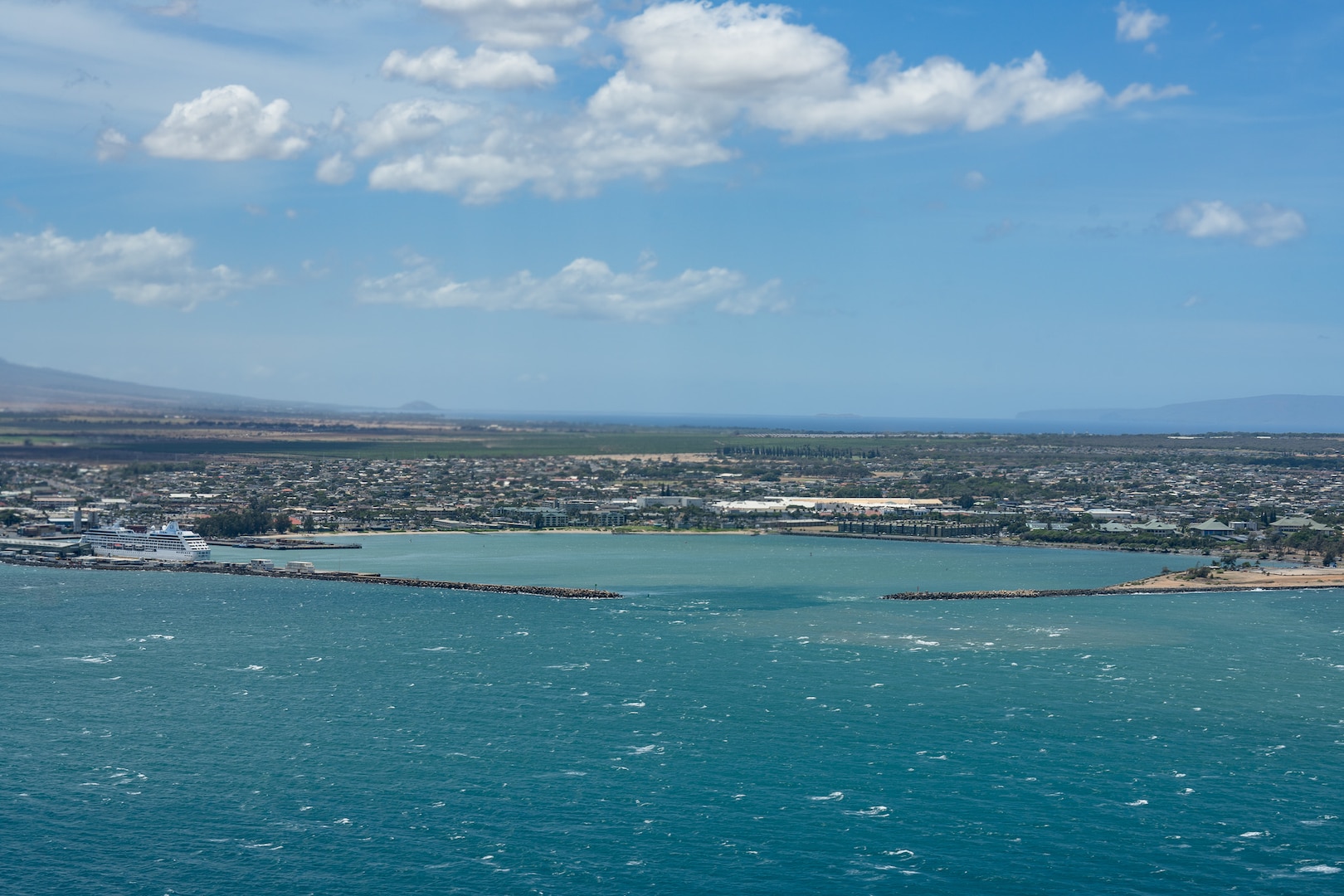 A crew from Coast Guard Air Station Barbers Point flies an HC-130 Hercules aircraft over Kahului Harbor, Maui, July 30, 2025. The crew assessed the condition of harbors, waterways, and aids to navigation across the Hawaiian Islands following the end of a tsunami advisory that had been issued across Hawaii. (U.S. Coast Guard photo by Petty Officer 3rd Class Avery Tibbets)