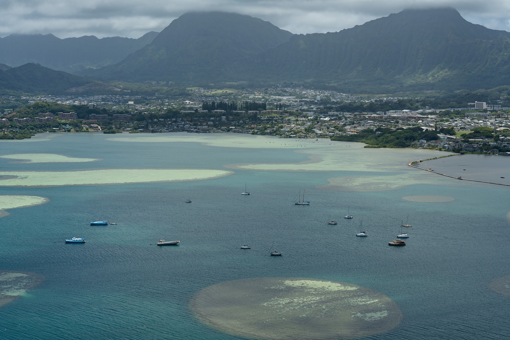 A crew from Coast Guard Air Station Barbers Point, flying in an HC-130 Hercules aircraft, views Kaneohe Bay, Oahu, from above, July 30, 2025. The crew conducted an assessment of harbors, waterways and aids to navigation following the end of a tsunami advisory, and found no observable hazards or pollution. (U.S. Coast Guard photo by Petty Officer 3rd Class Avery Tibbets)