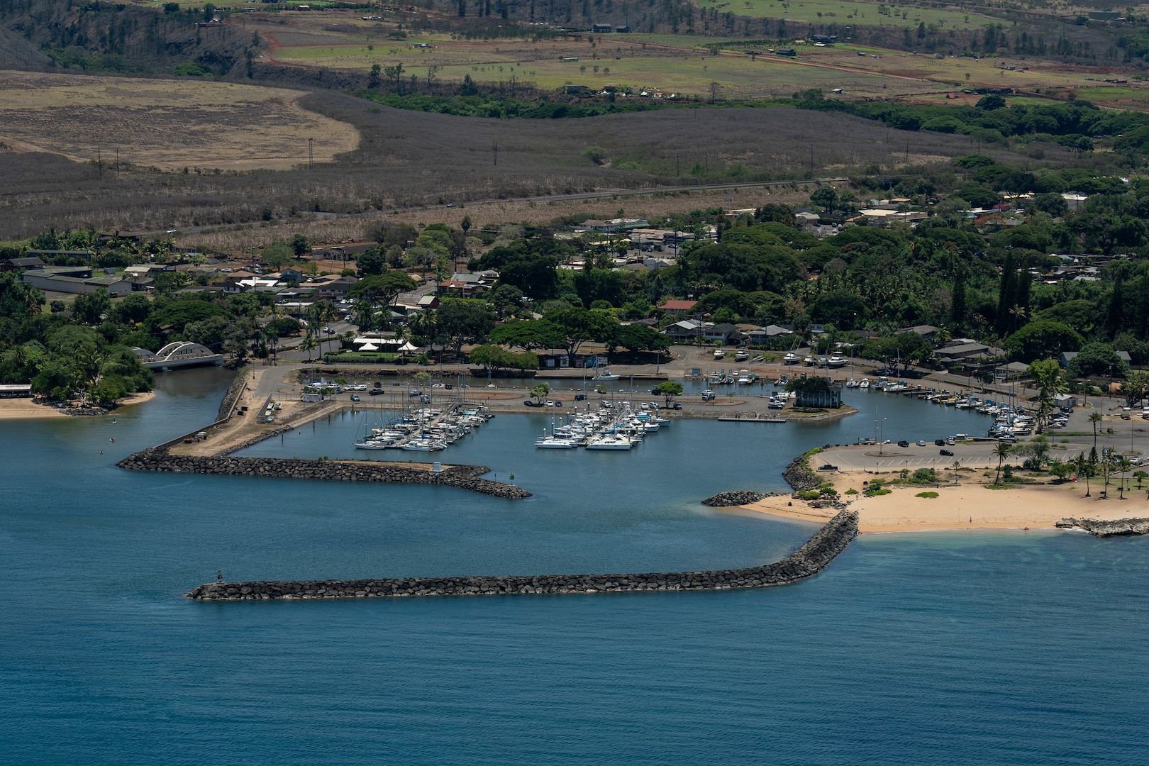 A crew from Coast Guard Air Station Barbers Point observes Haleiwa Harbor, Oahu, from an HC-130 Hercules, July 30, 2025. The crew flew over a number of the Hawaiian Islands to assess the condition of harbors, waterways and aids to navigation following the end of a tsunami advisory that had been issued for the State of Hawaii. (U.S. Coast Guard photo by Petty Officer 3rd Class Avery Tibbets).