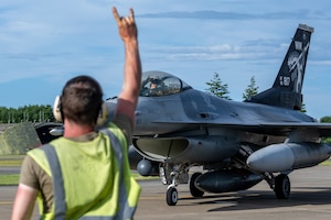 U.S. Air Force Capt. Eric Murray, 14th Fighter Squadron F-16 Fighting Falcon pilot, responds with a “Samurai Wood” hand sign to a 14th Fighter Generation Squadron Airman  during exercise Resolute Force Pacific 2025