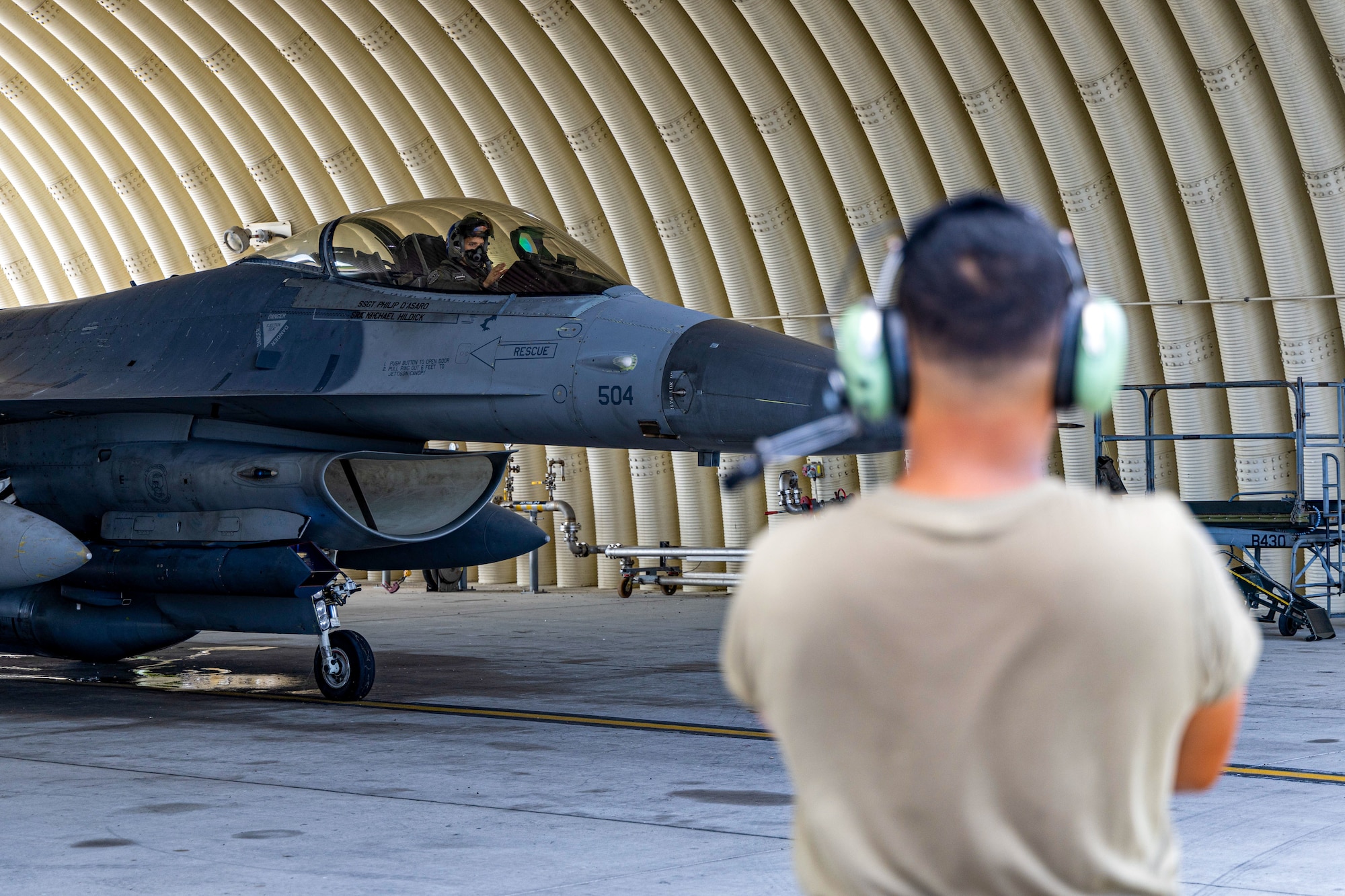 An 8th Maintenance Group crew chief watches an F-16 Fighting Falcon aircraft prepare to taxi