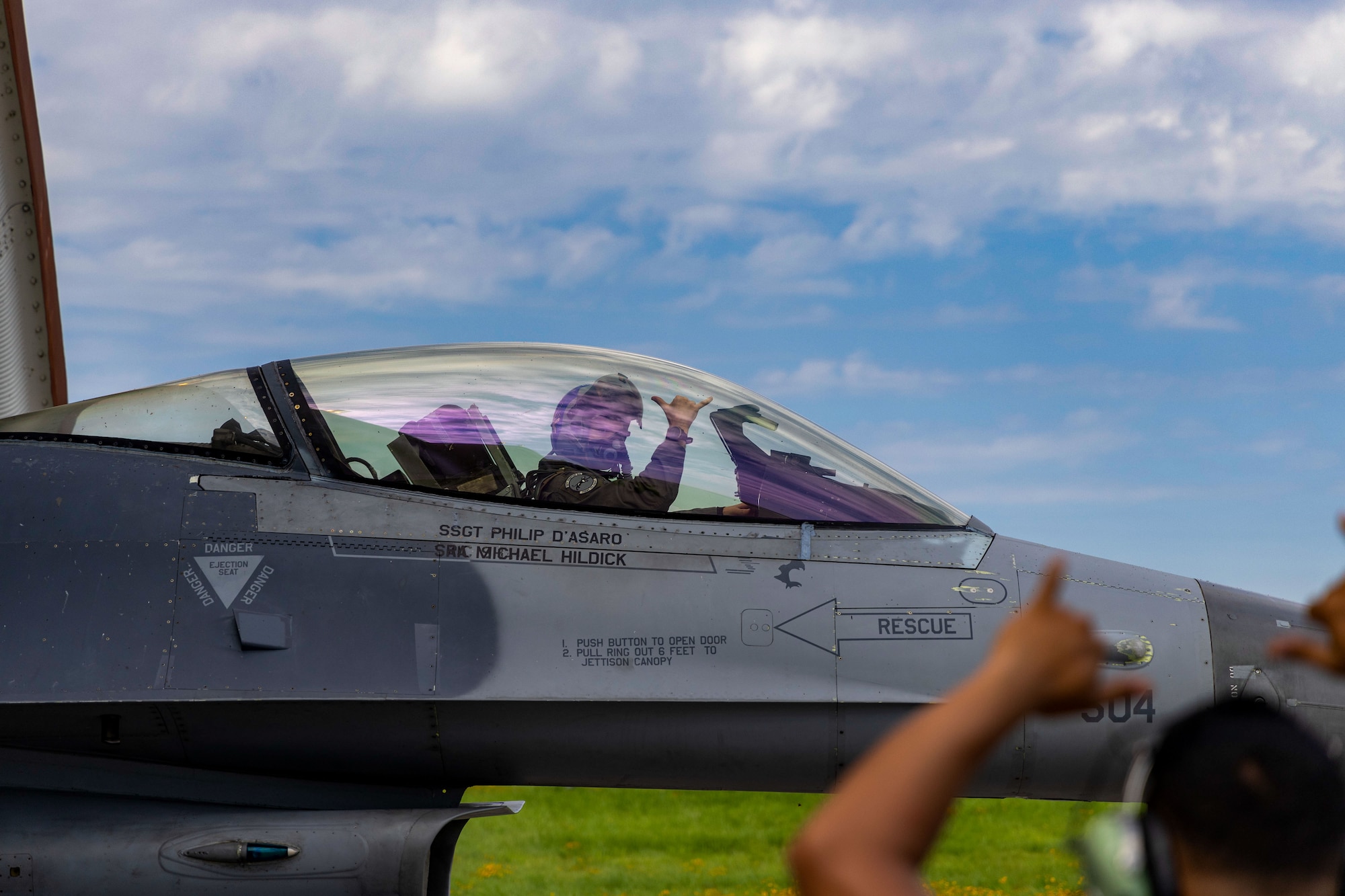 A 35th Fighter Squadron pilot in an F-16 Fighting Falcon aircraft flashes the “push it up” hand sign to an 8th Maintenance Group crew chief