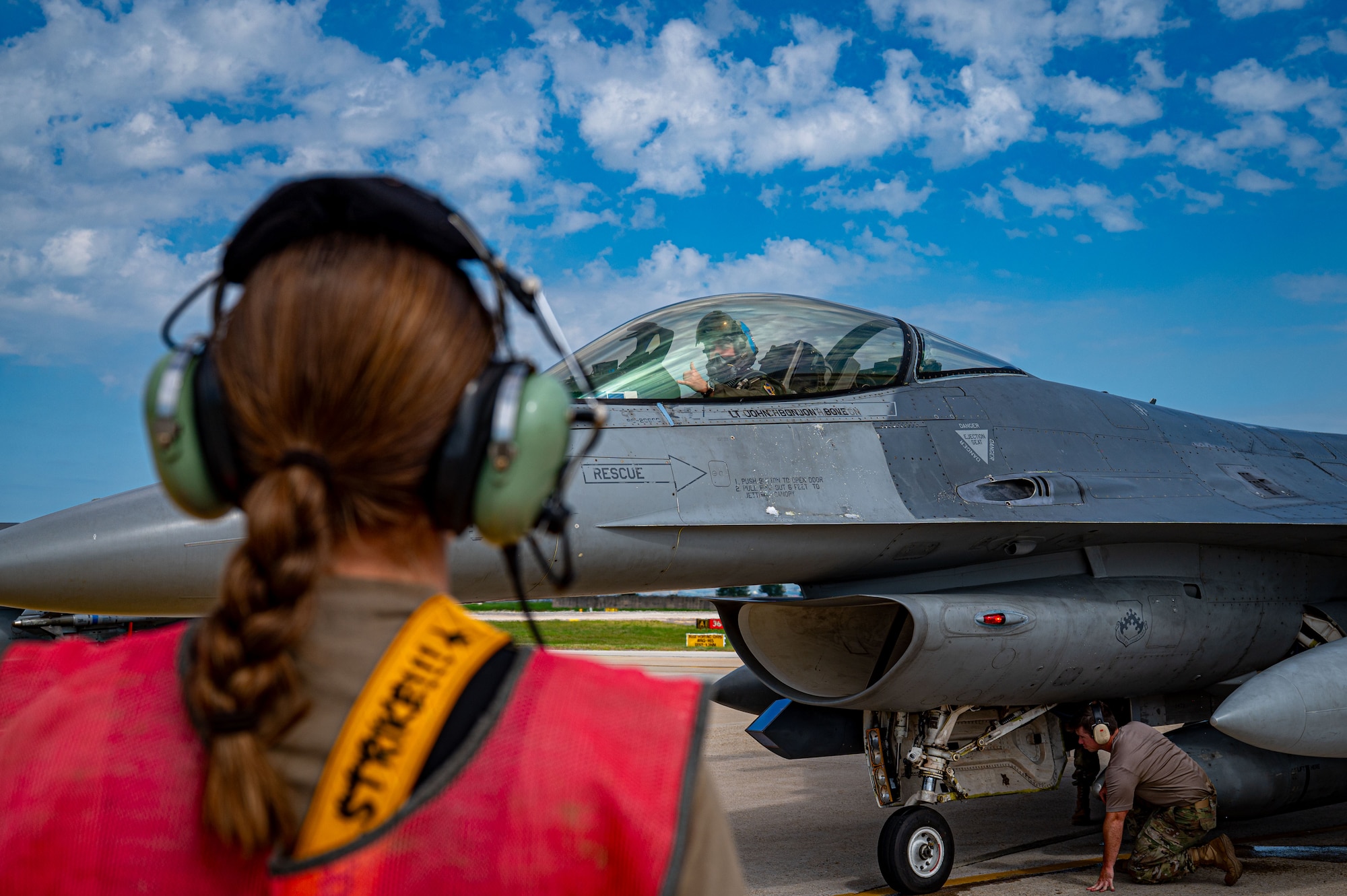 A 35th Fighter Squadron pilot in an F-16 Fighting Falcon aircraft flashes the “push it up” hand sign to an 8th Maintenance Group crew chief