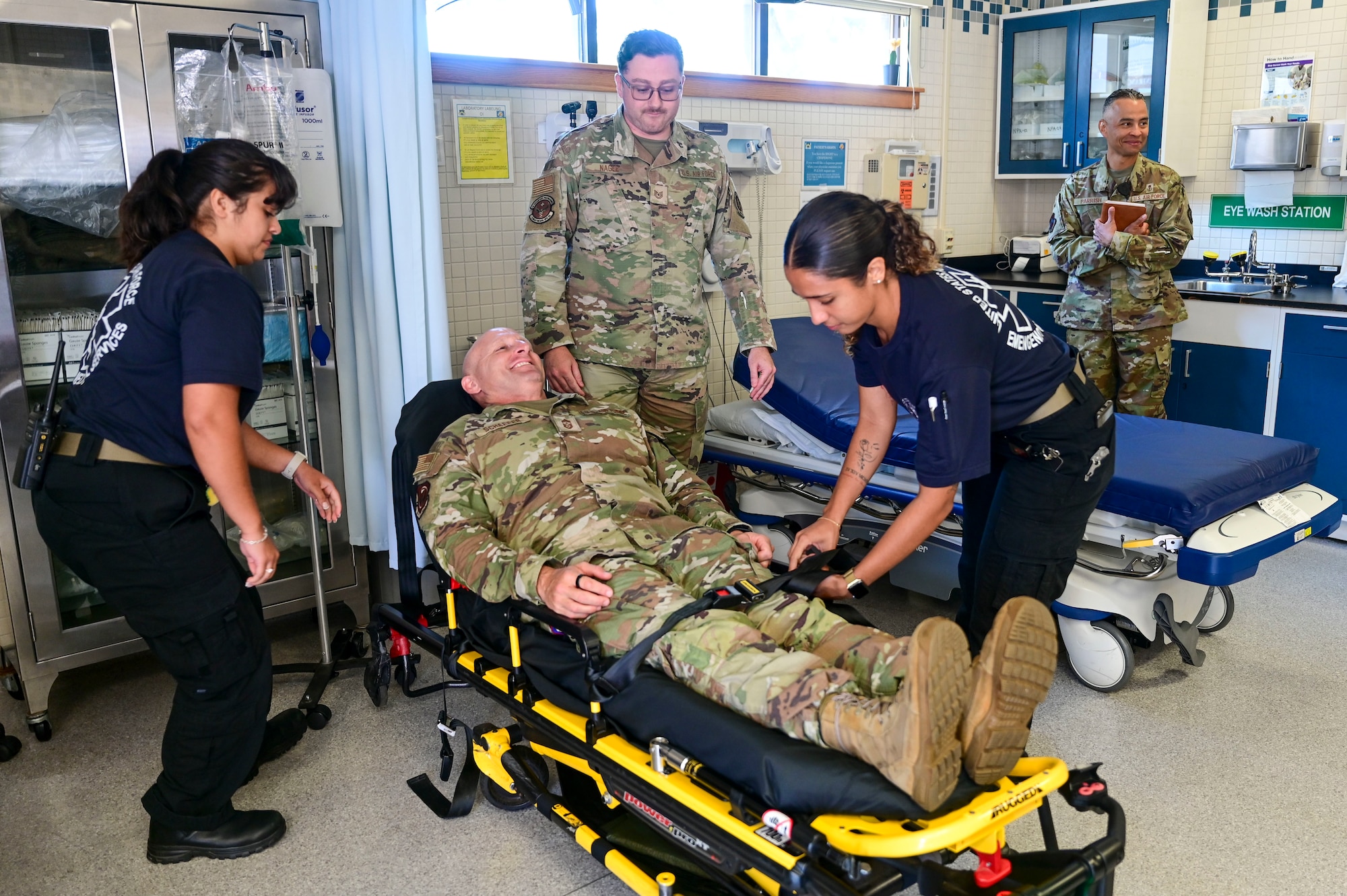 Chief Master Sgt. Thomas Schaefer II, Seventh Air Force command chief, is secured on a power-lift stretcher by members of the 8th Medical Group ambulance services team at Kunsan Air Base, Republic of Korea, July 29, 2025. The 8th MDG ambulance services team demonstrated how the stretcher is used to transport patients, gave Schaefer a tour of an ambulance and discussed how their services are used during exercises.