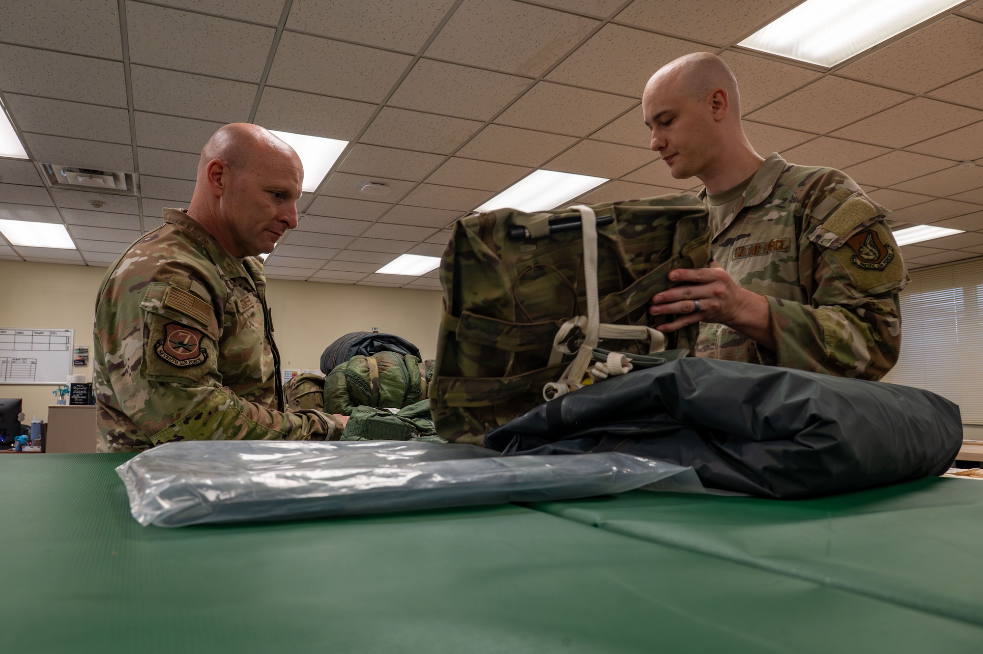 Tech. Sgt. George Schwetz, 8th Operations Support Squadron aircrew flight equipment specialist flight chief, demonstrates his team’s work to repack F-16 Fighting Falcon ejection seats to Chief Master Sgt. Thomas Schaefer II, Seventh Air Force command chief at Kunsan Air Base, Republic of Korea, July 30, 2025. Engaging directly with the Wolf Pack allowed Schaefer to gain insight into the unique culture and missions at Kunsan, while he reinforced the importance of leaders being present, informed, and invested in Airmen.