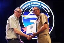 Vice Adm. Johnny R. Wolfe, Jr. awarded Mr. Horace “Hank” Lund  his  60 year Fleet Ballistic Program pin during the celebratory event at NewLife Training Center on 16 July, in honor of the 70th anniversary of Strategic Systems Programs. As a part of the SSP team, Strategic Weapons Facility Pacific provides dedication to assembling, maintaining, and storing Trident II D5 Missiles and deploying them on fleet ballistic missile submarines. We are devoted to serving our nation by providing safe, secure, credible, and affordable sea-based missile systems. The ceremony is one of several events leading up to SSP’s anniversary on November 17, 2025, intended to highlight the vast network of people and expertise required to ensure SSP’s no-fail mission. Since SSP was stood up in 1955, it has retained the cradle-to-grave responsibility for the submarine-launched ballistic missile (SLBM) strategic weapon system. Today, that system is the Trident II D5LE deployed on Ohio-class SSBNs for strategic patrol, supporting the U.S. Navy’s role in maintaining peace through strength. SSP is also modernizing the Navy’s SWS for the future Columbia-class SSBNs and is pioneering advanced regional strike capabilities with SLCM-N and the non-nuclear CPS programs to enhance our nation’s maritime dominance. This year’s celebration coincides with the 250th birthday of the U.S. Navy on Oct. 13. For 250 years, America’s Navy has promoted prosperity and security, deterred aggression, and protected the American way of life.” (U.S. Navy photo by Cody Brown/Released)