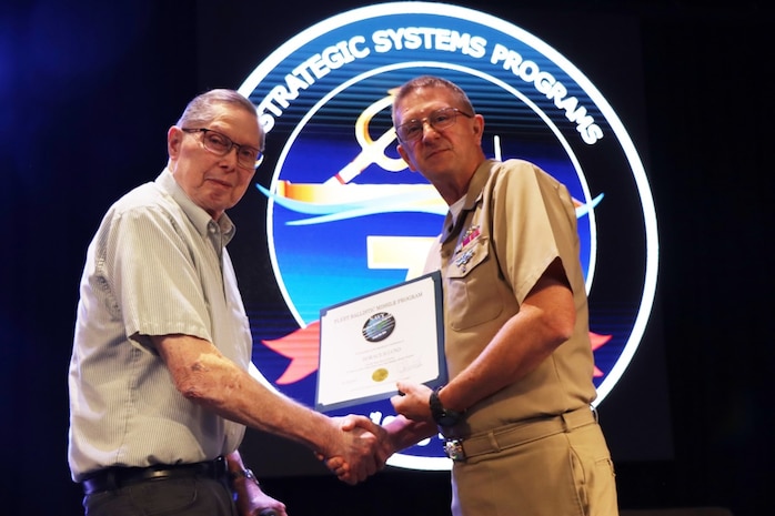 Vice Adm. Johnny R. Wolfe, Jr. awarded Mr. Horace “Hank” Lund  his  60 year Fleet Ballistic Program pin during the celebratory event at NewLife Training Center on 16 July, in honor of the 70th anniversary of Strategic Systems Programs. As a part of the SSP team, Strategic Weapons Facility Pacific provides dedication to assembling, maintaining, and storing Trident II D5 Missiles and deploying them on fleet ballistic missile submarines. We are devoted to serving our nation by providing safe, secure, credible, and affordable sea-based missile systems. The ceremony is one of several events leading up to SSP’s anniversary on November 17, 2025, intended to highlight the vast network of people and expertise required to ensure SSP’s no-fail mission. Since SSP was stood up in 1955, it has retained the cradle-to-grave responsibility for the submarine-launched ballistic missile (SLBM) strategic weapon system. Today, that system is the Trident II D5LE deployed on Ohio-class SSBNs for strategic patrol, supporting the U.S. Navy’s role in maintaining peace through strength. SSP is also modernizing the Navy’s SWS for the future Columbia-class SSBNs and is pioneering advanced regional strike capabilities with SLCM-N and the non-nuclear CPS programs to enhance our nation’s maritime dominance. This year’s celebration coincides with the 250th birthday of the U.S. Navy on Oct. 13. For 250 years, America’s Navy has promoted prosperity and security, deterred aggression, and protected the American way of life.” (U.S. Navy photo by Cody Brown/Released)