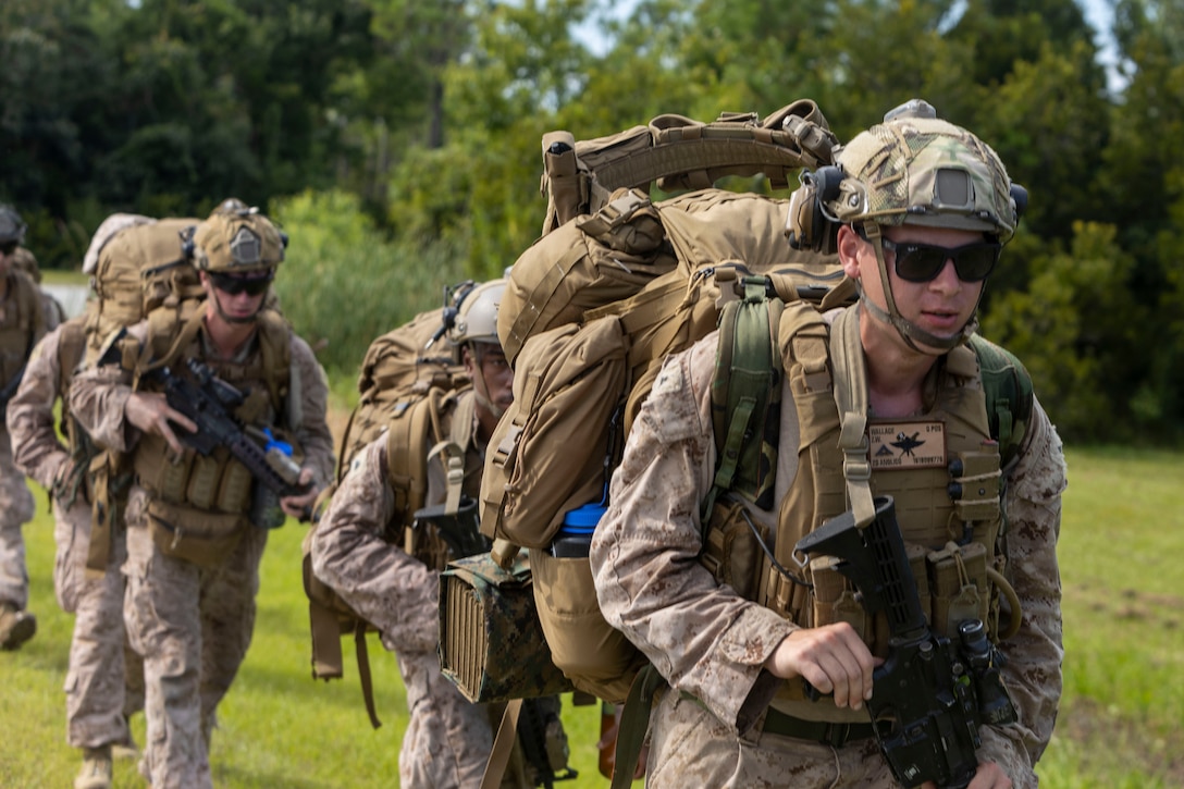 U.S. Marines with 2nd Air Naval Gunfire Liaison Company, II Marine Expeditionary Force Information Group, ruck to their objective point during exercise Burmese Chase 25, at Marine Corps Outlying Field Atlantic, North Carolina, July 29, 2025. Burmese Chase is an annual U.S. led, multi-lateral training exercise comprised of integrating ground and air fires, infantry tactics and naval gunfire alongside NATO allies to enhance combat readiness and interoperability. (U.S. Marine Corps photo by Cpl. Marc Imprevert)