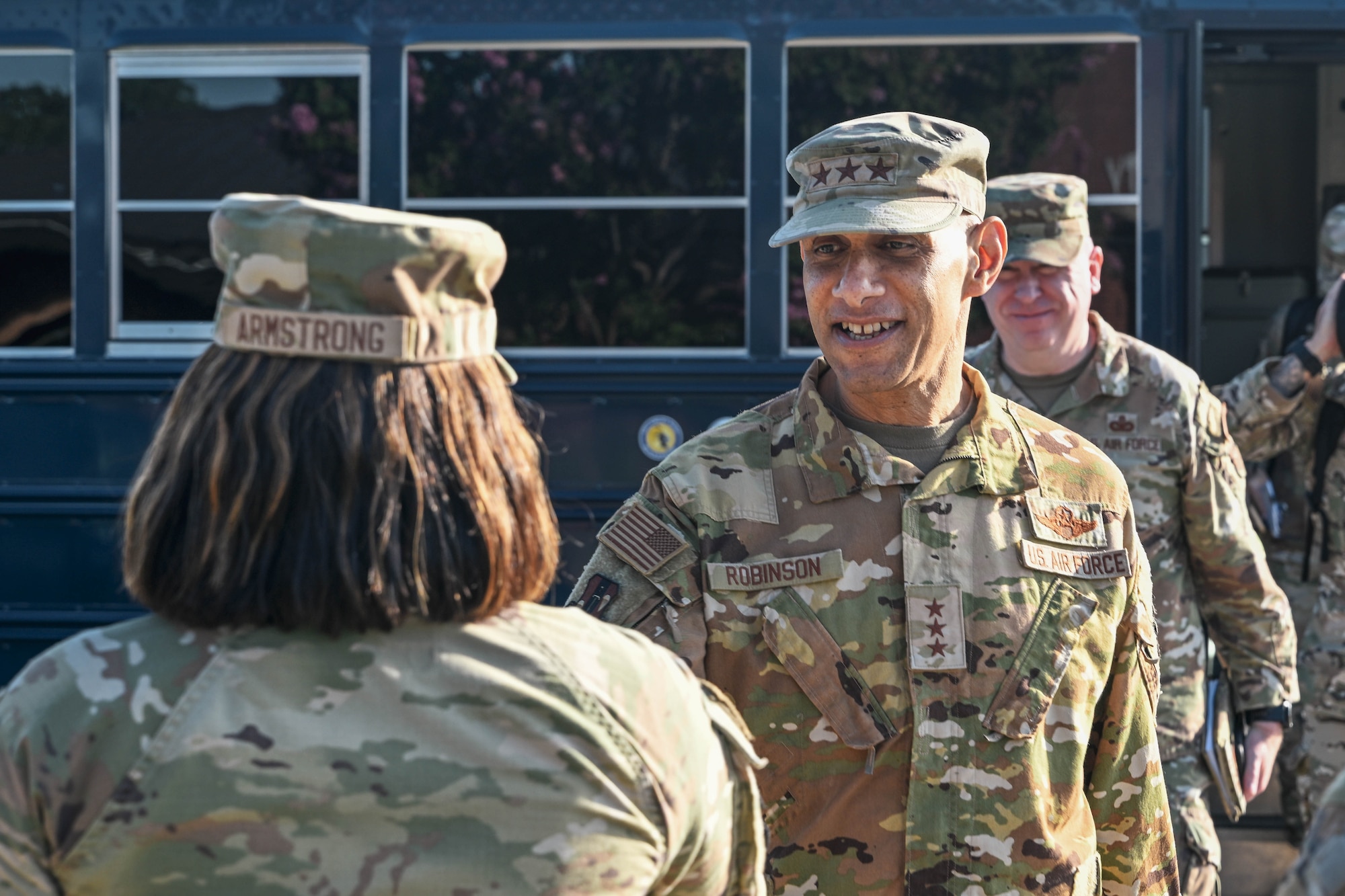 A man in uniform speaks to a woman in uniform.
