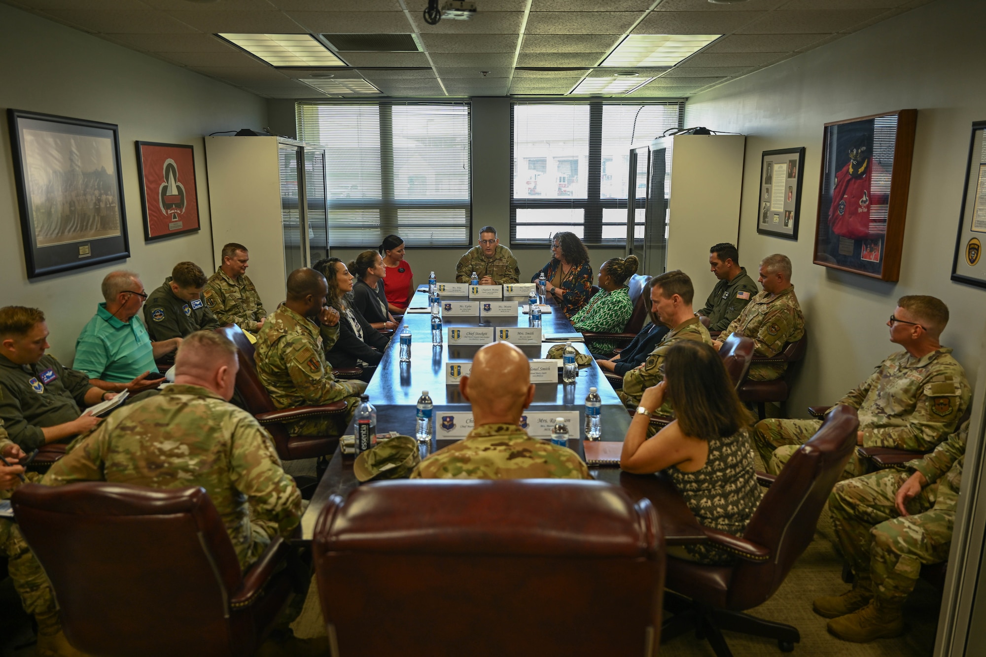 People in uniform and civilians listen to a presentation.
