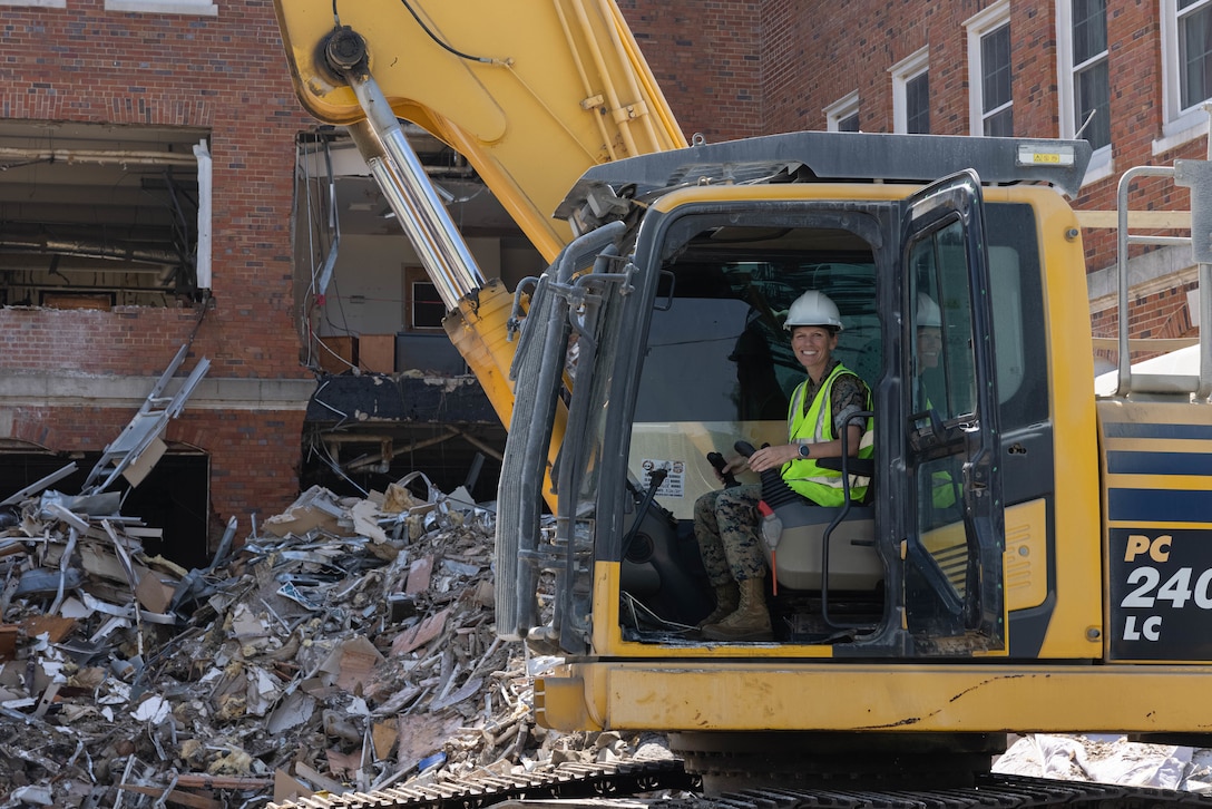 U.S. Marine Corps Col. Jenny Colegate, commanding officer of Marine Corps Base Quantico, poses for a photo after demolishing part of Robinson Hall on MCB Quantico, Virginia, July 29, 2025. Robinson Hall is being demolished in order to continue safe flight operations aboard Marine Corps Air Facilities Quantico. A former bachelor enlisted barracks, it was built in 1940 and was named after 1st Lt. Robert Guy Robinson, who was awarded the Purple Heart and Medal of Honor during World War I. (U.S. Marine Corps photo by Lance Cpl. David Brandes)