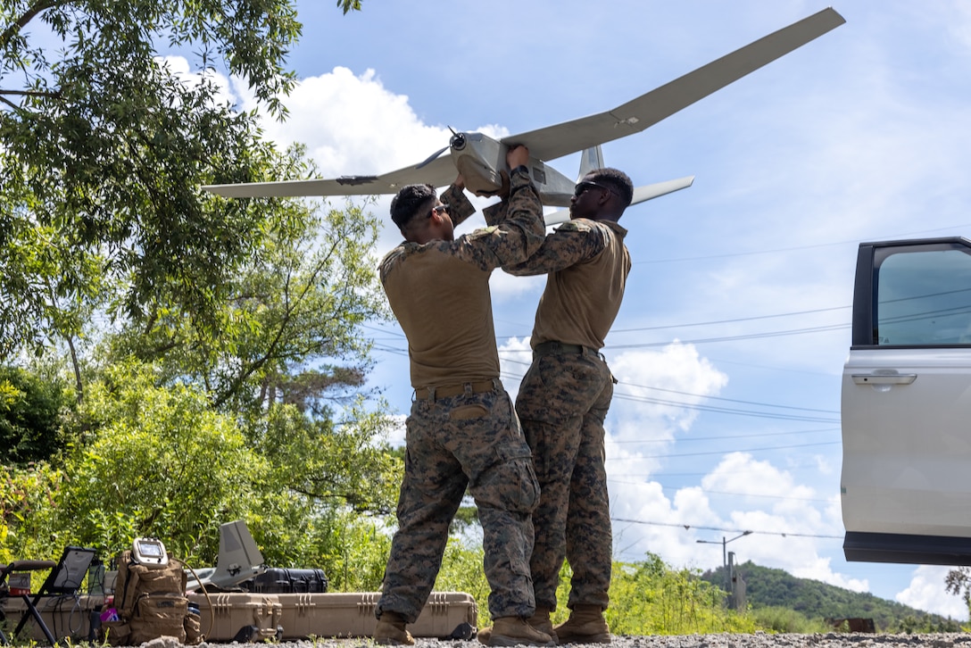 U.S. Marine Corps Lance Cpl. Jonathan Yepez, left, a light armored reconnaissance scout, and Cpl. Carlisle Beach, an intelligence specialist, both with 3d LAR Battalion, 1st Marine Division currently forward deployed in the Indo-Pacific under 4th Marine Regiment, 3d Marine Division as part of the Unit Deployment Program, secure the wings of an RQ-20B Puma to its body during Korean Marine Exercise Program 25.2 in Pohang, South Korea, July 22, 2025. KMEP is a semi-annual exercise that provides iterative opportunities for Republic of Korea Marine Corps and U.S. Marine Corps units to train together, improving their combined capabilities to deter threats and maintain peace on the Korean Peninsula. Yepez is a native of Illinois, and Beach is a native of Massachusetts. (U.S. Marine Corps photo by Cpl. Peter J. Eilen)