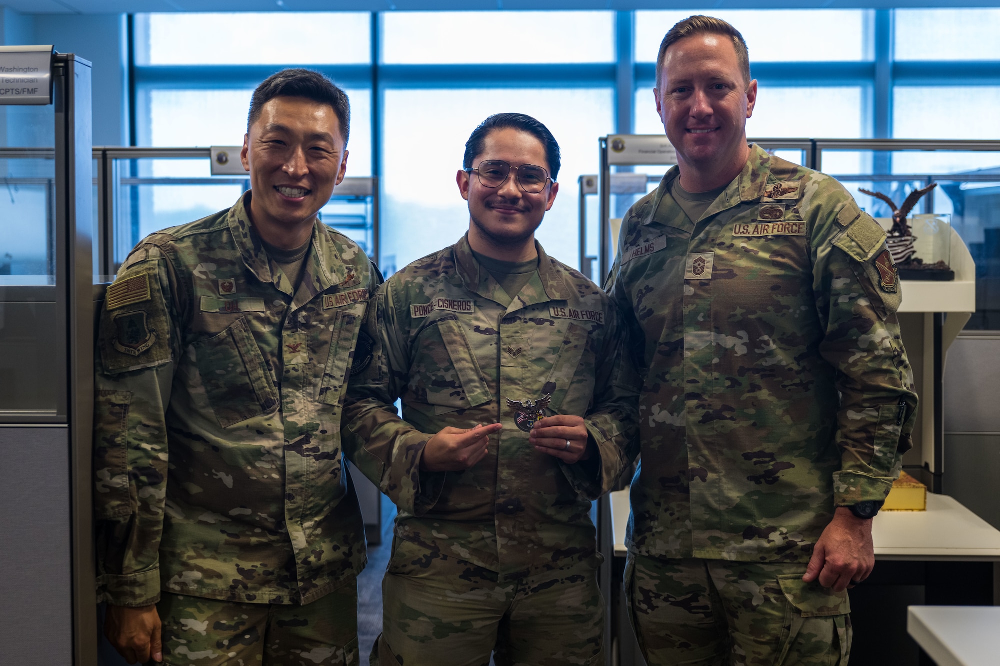 Senior Airman Bryan Ponce-Cisneros poses with base leadership after being recognized for Winnin' like a Griffin.