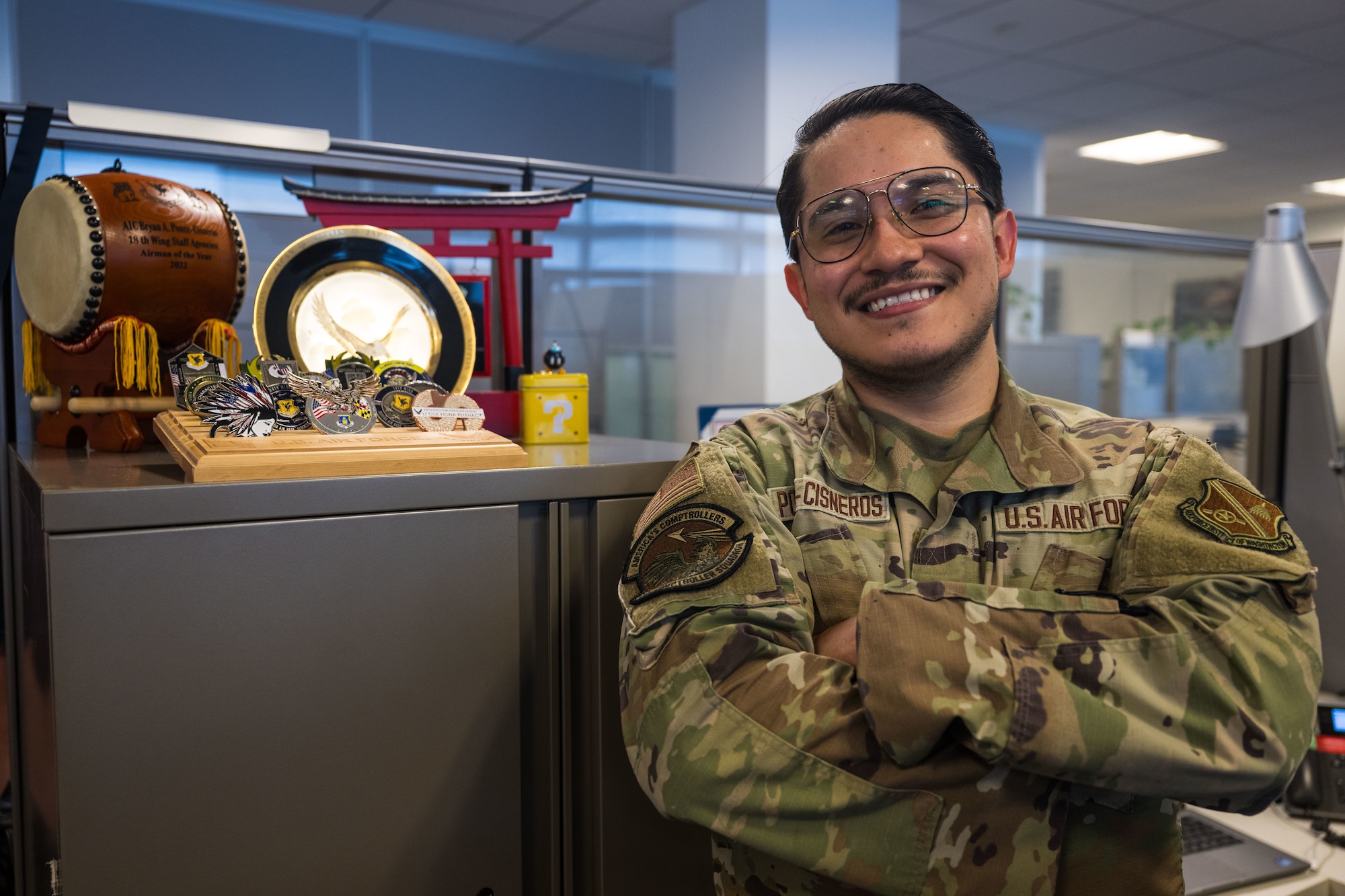U.S. Air Force Senior Airman Bryan Ponce-Cisneros, poses next to his awards and coins.