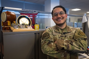 U.S. Air Force Senior Airman Bryan Ponce-Cisneros, poses next to his awards and coins.