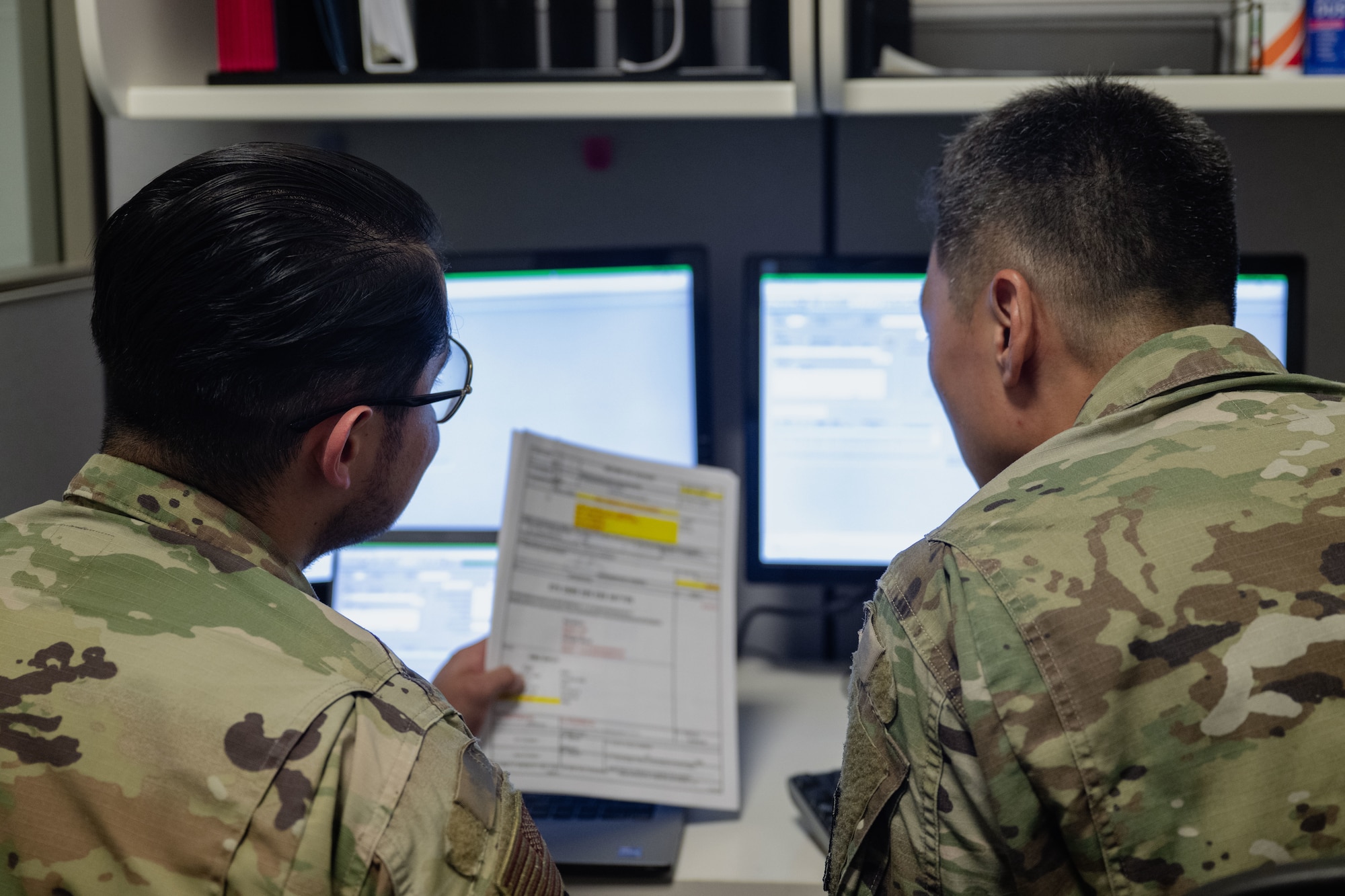 Senior Airman Bryan Ponce-Cisneros explains the financial form procedures to Col. Jun Oh.