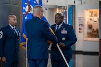 U.S. Air Force Maj. Gen. Daniel A. DeVoe, Air Force District of Washington and 320th Air Expeditionary Wing commander, passes the Air Force Provisional Flag, to Col. Ryan L. O’Neal, new commander of the 77th Intelligence Wing during the 77th IW Activation and Assumption of Command Ceremony at Joint Base Anacostia-Bolling, Washington, D.C., July 24, 2025.