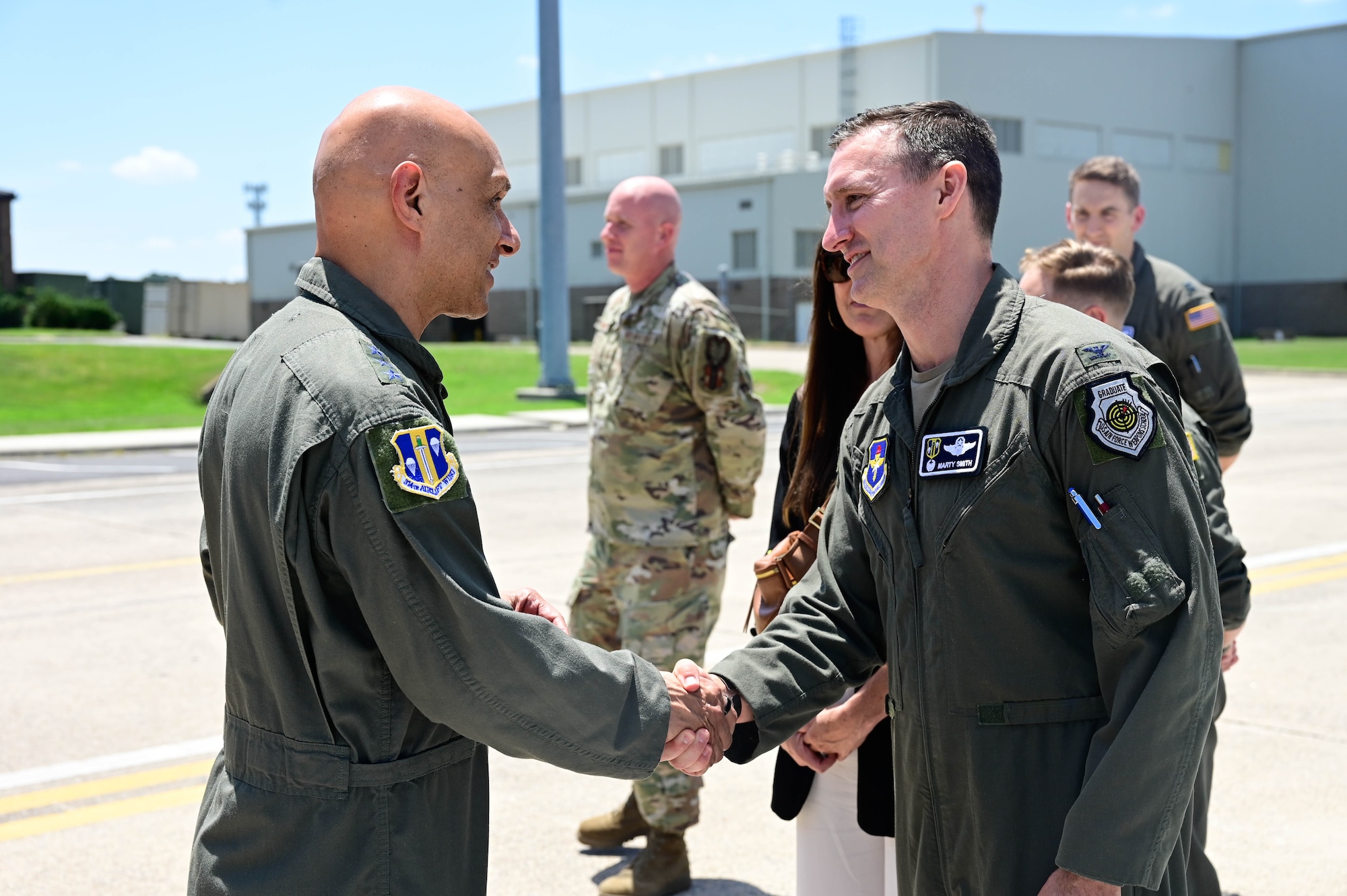 A man in uniform shakes the hand of another man in uniform.