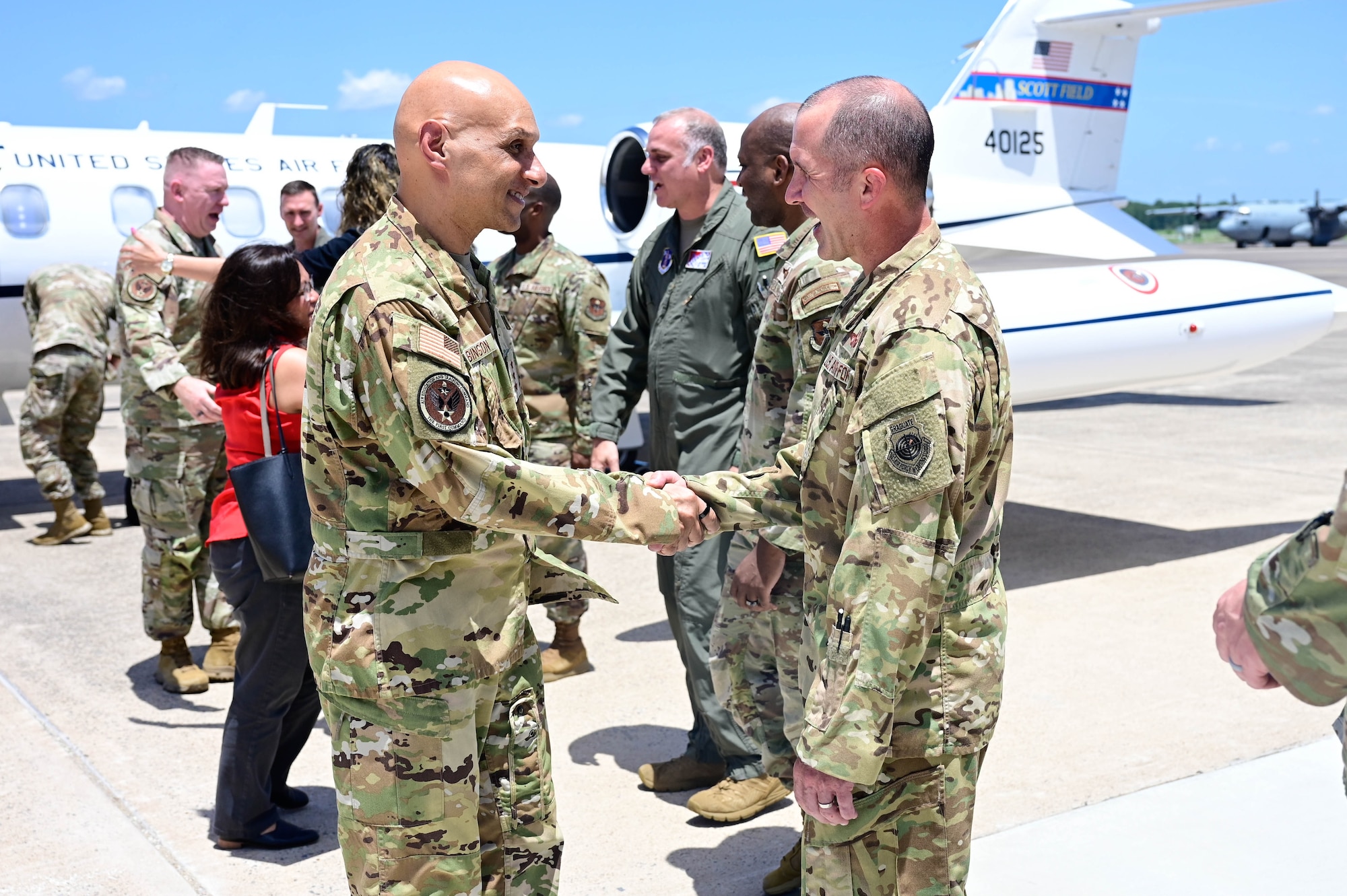 A man in uniform greets another man in uniform.