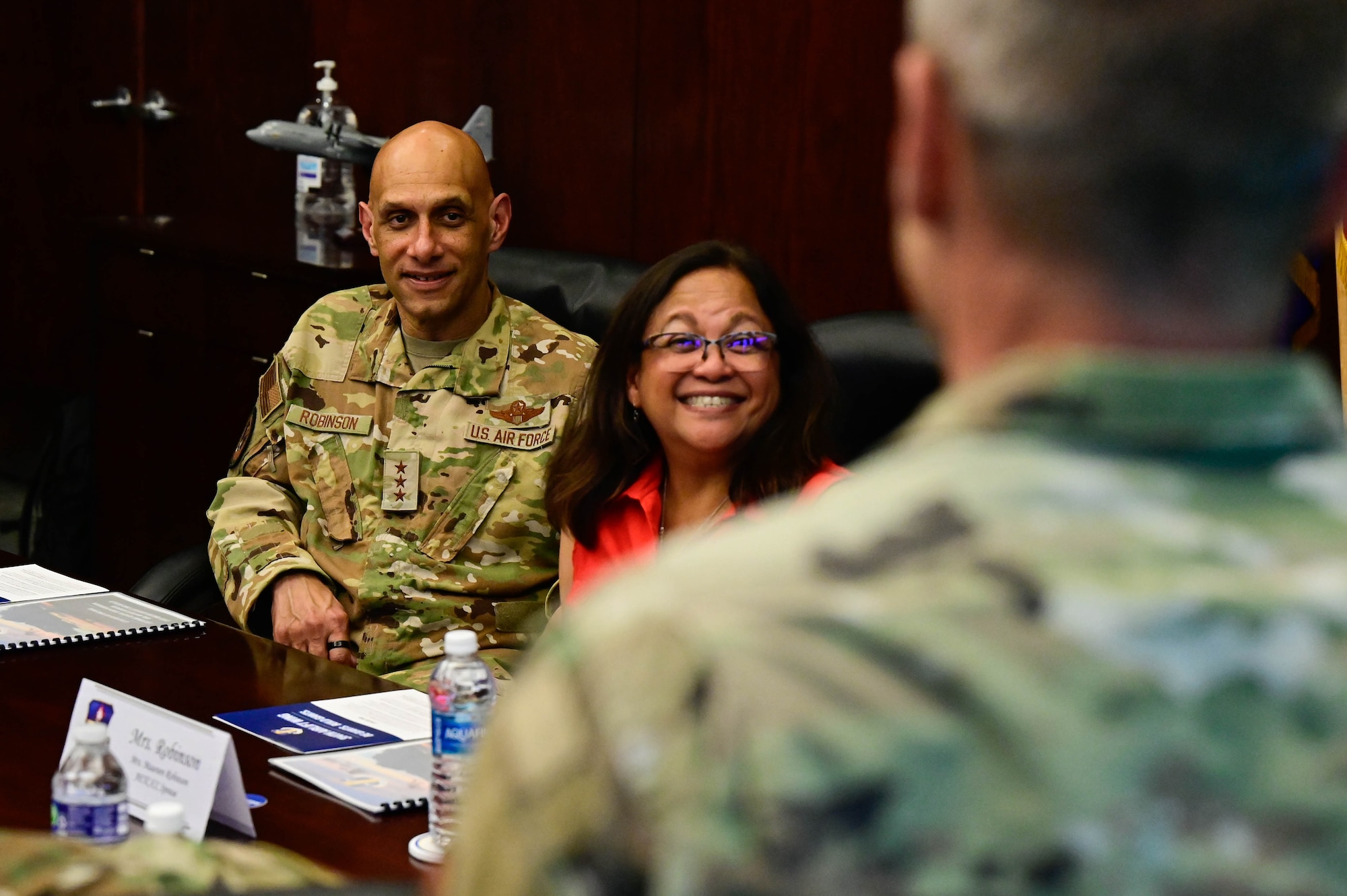 A man in uniform sits with his wife.