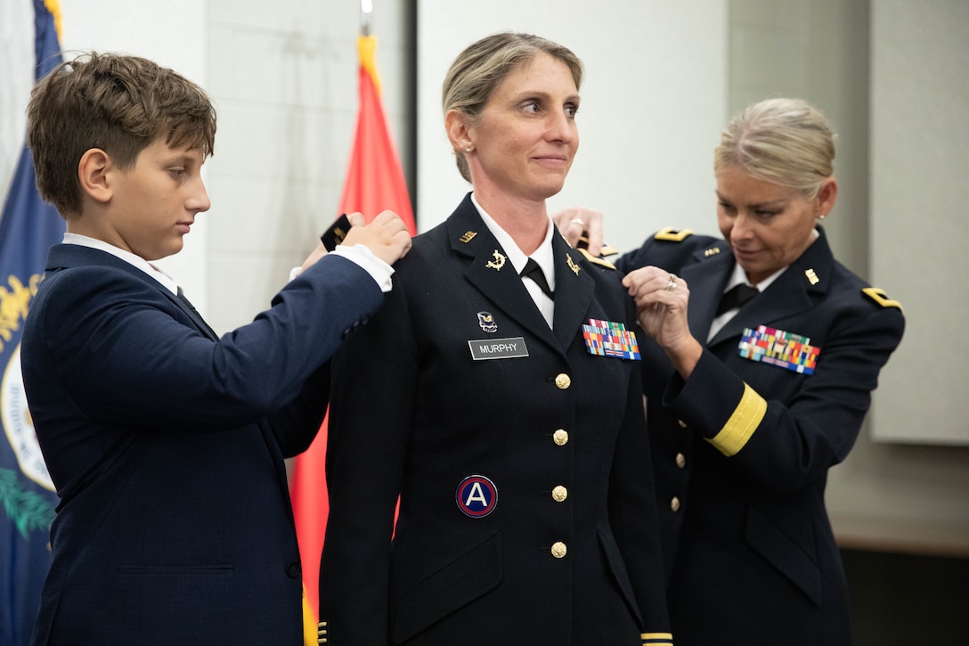 Col. Murphy’s rank is pinned by her son, Brennan, and Brig Gen. Natalie Lewellen during a promotion ceremony at the Wellman Auditorium at Boone National Guard Center in Frankfort, Jul 22, 2025. Murphy has served since 1997, most recently with the Office of Special Victims’ Counsel. (U.S. Army photo by Milt Spalding)