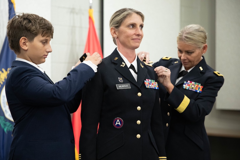 Col. Murphy’s rank is pinned by her son, Brennan, and Brig Gen. Natalie Lewellen during a promotion ceremony at the Wellman Auditorium at Boone National Guard Center in Frankfort, Jul 22, 2025. Murphy has served since 1997, most recently with the Office of Special Victims’ Counsel. (U.S. Army photo by Milt Spalding)