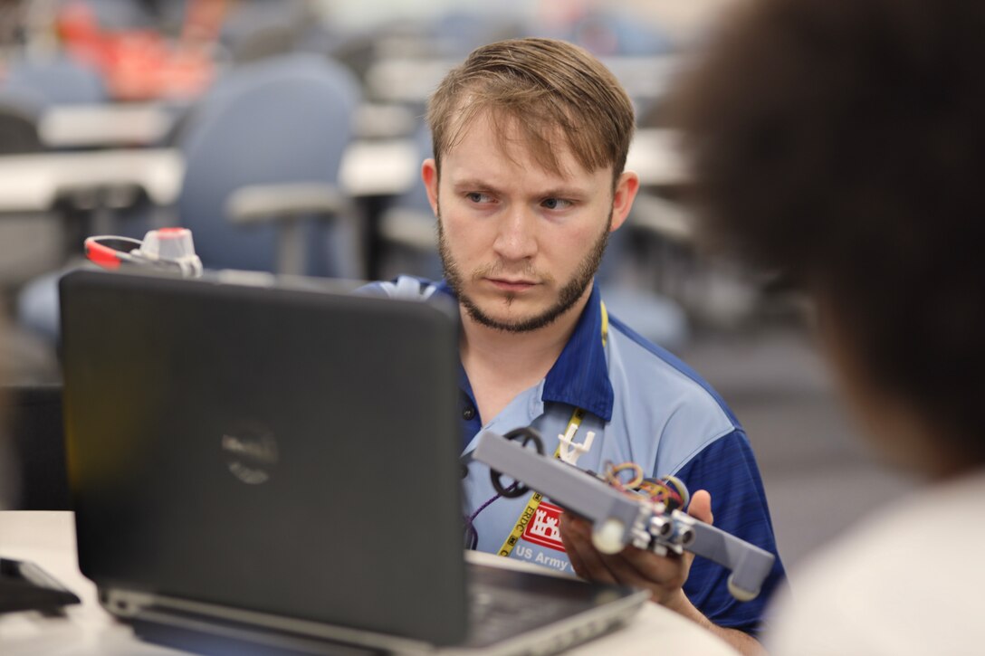 Middle school students participate in STEM activities involving chemistry and robotics to learn science and engineering technical skills.