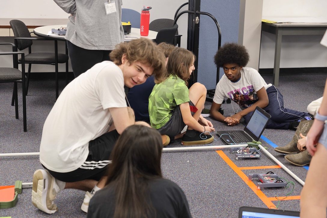 Middle school students participate in STEM activities involving chemistry and robotics to learn science and engineering technical skills.