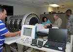 Dr. Victor Convertino, second from right, works with colleagues to place monitors on a volunteer in the U.S. Army Institute of Surgical Research lower body negative pressure chamber to collect physiological data as part of a research protocol.