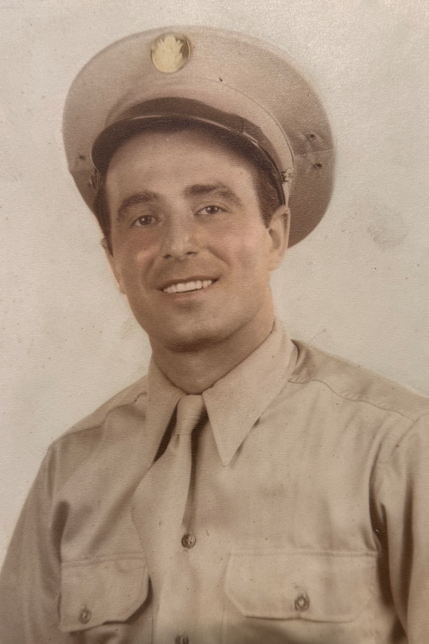A man in a military uniform poses for a passport-style photo.