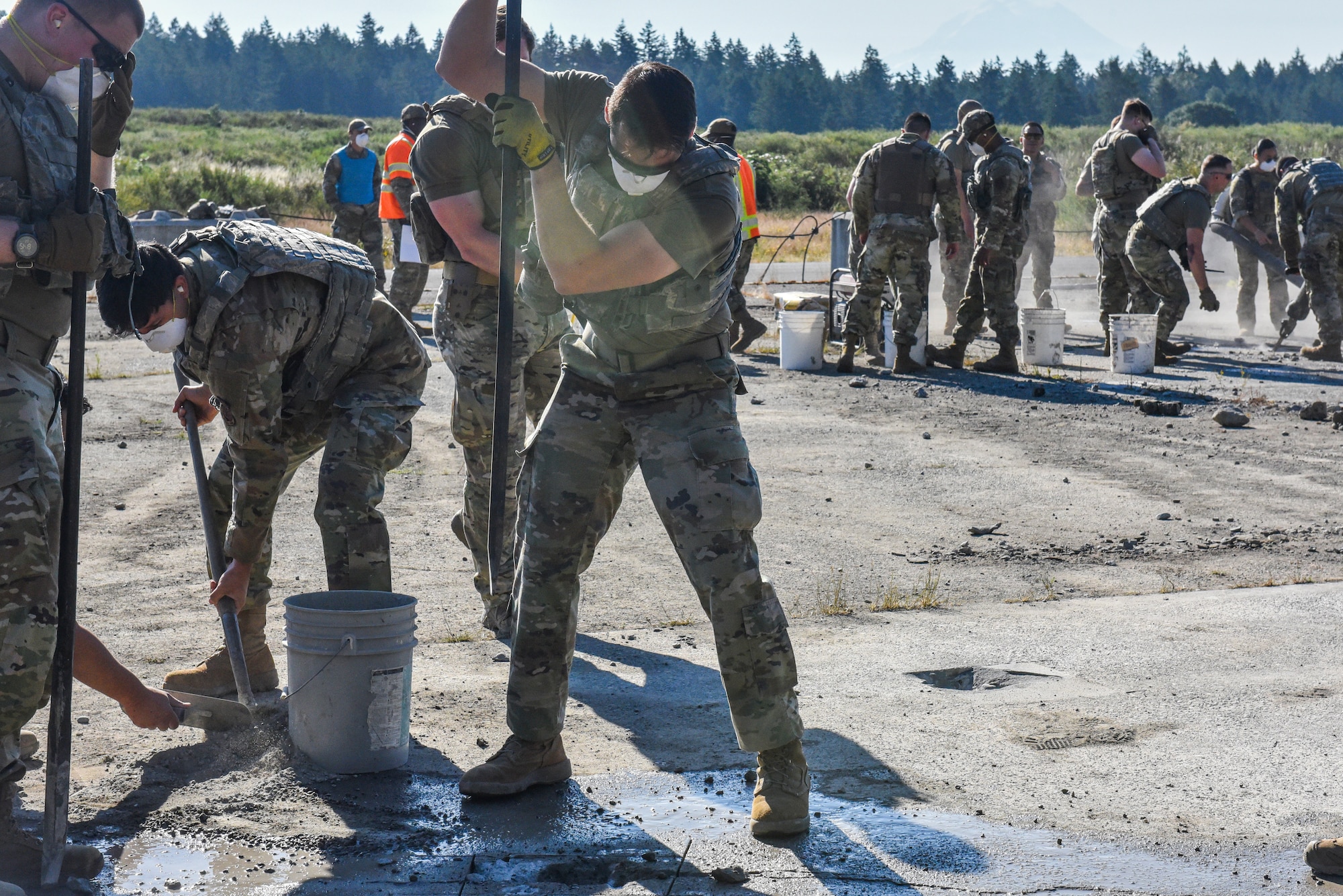 U.S. Air Force Senior Airman Jarrett Perez, center, and fellow Julius A. Kolb Airman Leadership School class 25-Echo students conduct spall repair training at Joint Base Lewis-McChord, Washington, July 8, 2025.