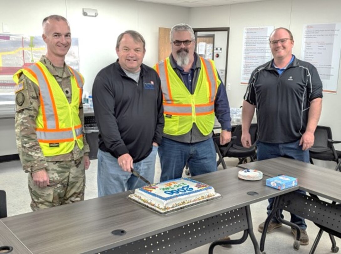 Detroit District Commander, Lt. Col. Wallace Bandeff, INDC Lead Engineer Darin White, Senior Civilian Kevin McDaniels and KAT Design Engineer Nick Stromberg prepare to cut a cake in celebration of completing 2,000 technical submittals on the New Lock at the Soo project.