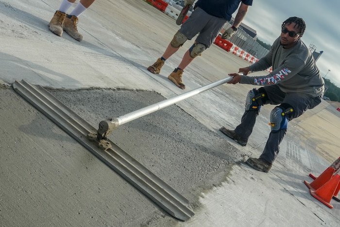 Tay Owens, a mason with the 78th Civil Engineer Squadron, was spreading freshly poured concrete into a taxiway repair hole at Robins Air Force Base, Georgia, July 24th, 2025.