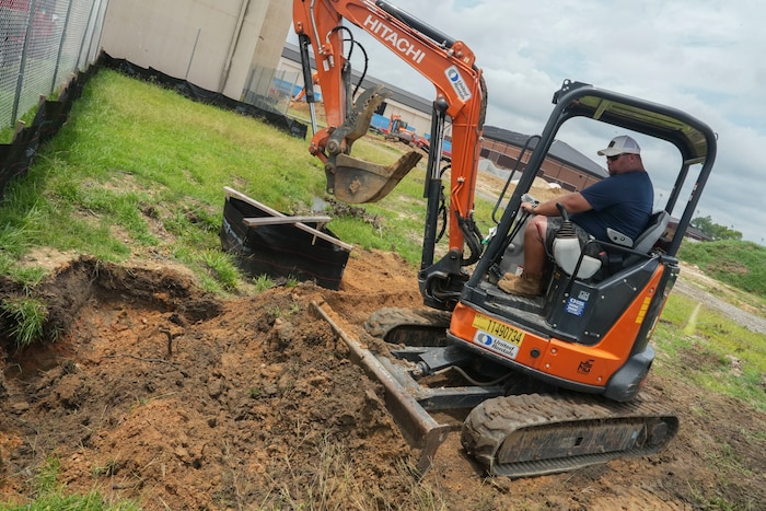 Michael Harrell, a 78th Civil Engineer Squadron equipment operator, unearths a section of dirt at Robins Air Force Base, Georgia, in preparation for gas line repairs.