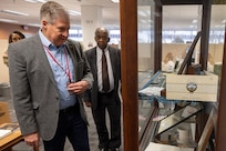 Stan Soderstrom, Civilian Aide to the Secretary of the Army, looks at artifacts from the history of the U.S. Army Financial Management Command as Ken Crowder, USAFMCOM Army Financial Services director, looks on during a visit to USAFMCOM at the Maj. Gen. Emmett J. Bean Federal Center in Indianapolis Feb. 11, 2025. Soderstrom met with Col. Michelle M. Williams, USAFMCOM commander, to learn more about USAFMCOM and offer his support to the command. (U.S. Army photo by Mark R. W. Orders-Woempner)