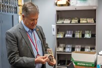 Stan Soderstrom, Civilian Aide to the Secretary of the Army, handles training currency during a visit to the U.S. Army Financial Management Command at the Maj. Gen. Emmett J. Bean Federal Center in Indianapolis Feb. 11, 2025. USAFMCOM uses the currency, which was created as props for big-budget movies, to train Army Finance Soldiers with more realism. (U.S. Army photo by Mark R. W. Orders-Woempner)