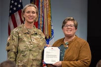 Col. Michelle M. Williams, U.S. Army Financial Management Command commander, presents the USAFMCOM Army Accounting and Audit Operations Fund Balance with Treasury team with certificates of appreciation from Christine Wormuth, Secretary of the Army, in recognition of their efforts to downgrade FBwT as a material weakness in the Army’s General Fund audit  during a town hall at the Maj. Gen. Emmett J. Bean Federal Center in Indianapolis Feb. 12, 2025. Pictured next to Williams, from left to right, are LuAnn Watson, Shannon Tabbert, Esther Richard, Cindy Price, Karen Percinel, Amanda McCoy, Denise Gallion, and Makayla Chriss. (U.S. Army photo by Mark R. W. Orders-Woempner)