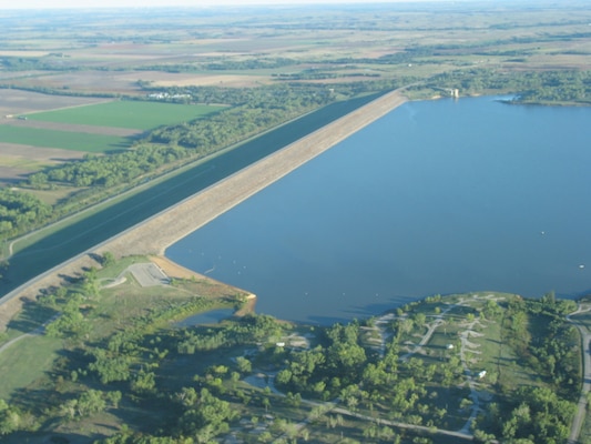 A blue body of water surrounded by green vegetation.