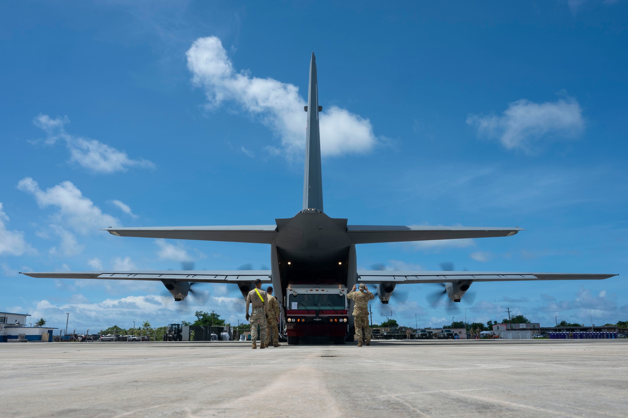 Aircrew load a firetruck onto an aircraft.