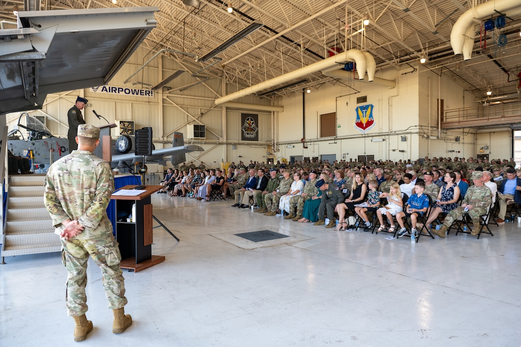 An audience listening to a speaker on stage.