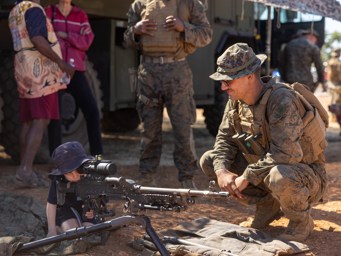 U.S. Marine Corps Cpl. Gabriel Stoy, a team leader with 2nd Battalion, 1st Marine Regiment, Marine Rotational Force – Darwin 25.3, shows an M240B medium machine gun to local youth during a family event in Cloncurry, Queensland, Australia, July 24, 2025.