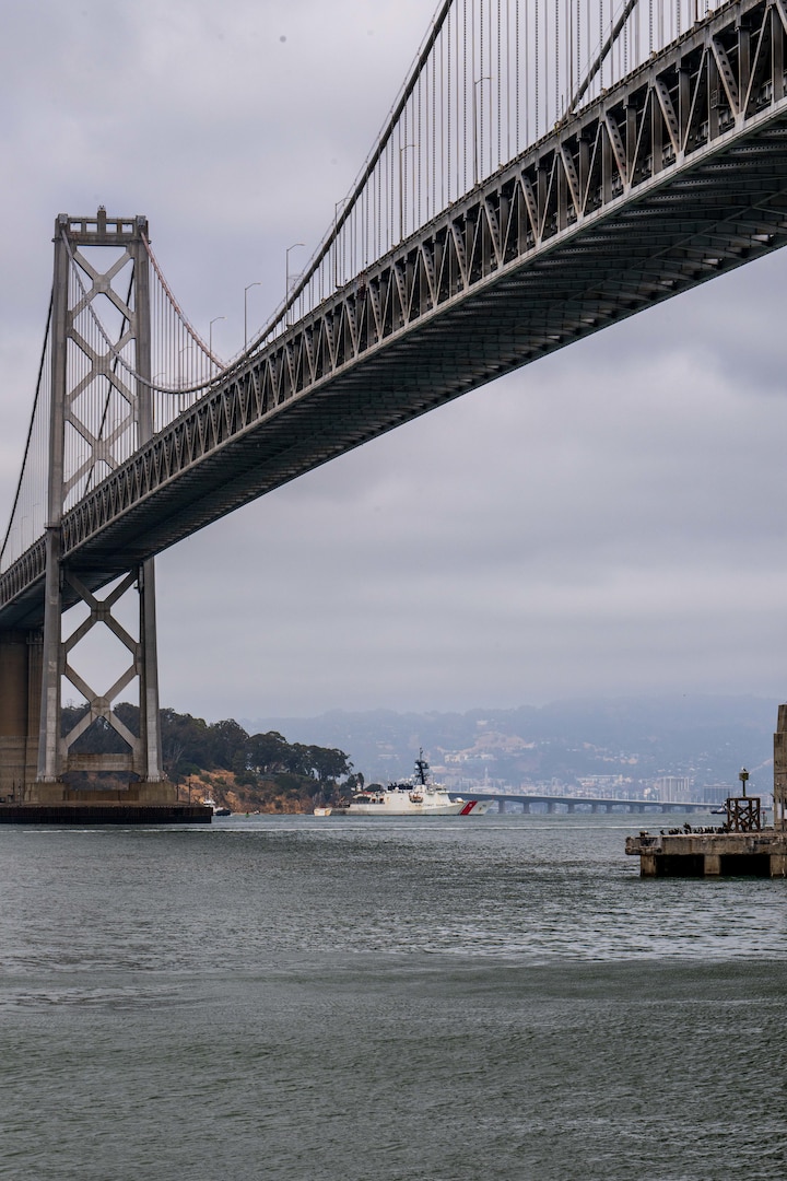U.S. Coast Guard Cutter Stratton (WMSL 752) crosses under the Bay Bridge while transiting toward its Base Alameda, California, home port following a 134-day Western Pacific patrol, July 30, 2025. Commissioned in 2012, Stratton is one of ten Legend-class national security cutters and one of four homeported in Alameda. (U.S. Coast Guard photo by Petty Officer 3rd Class Austin Wiley)