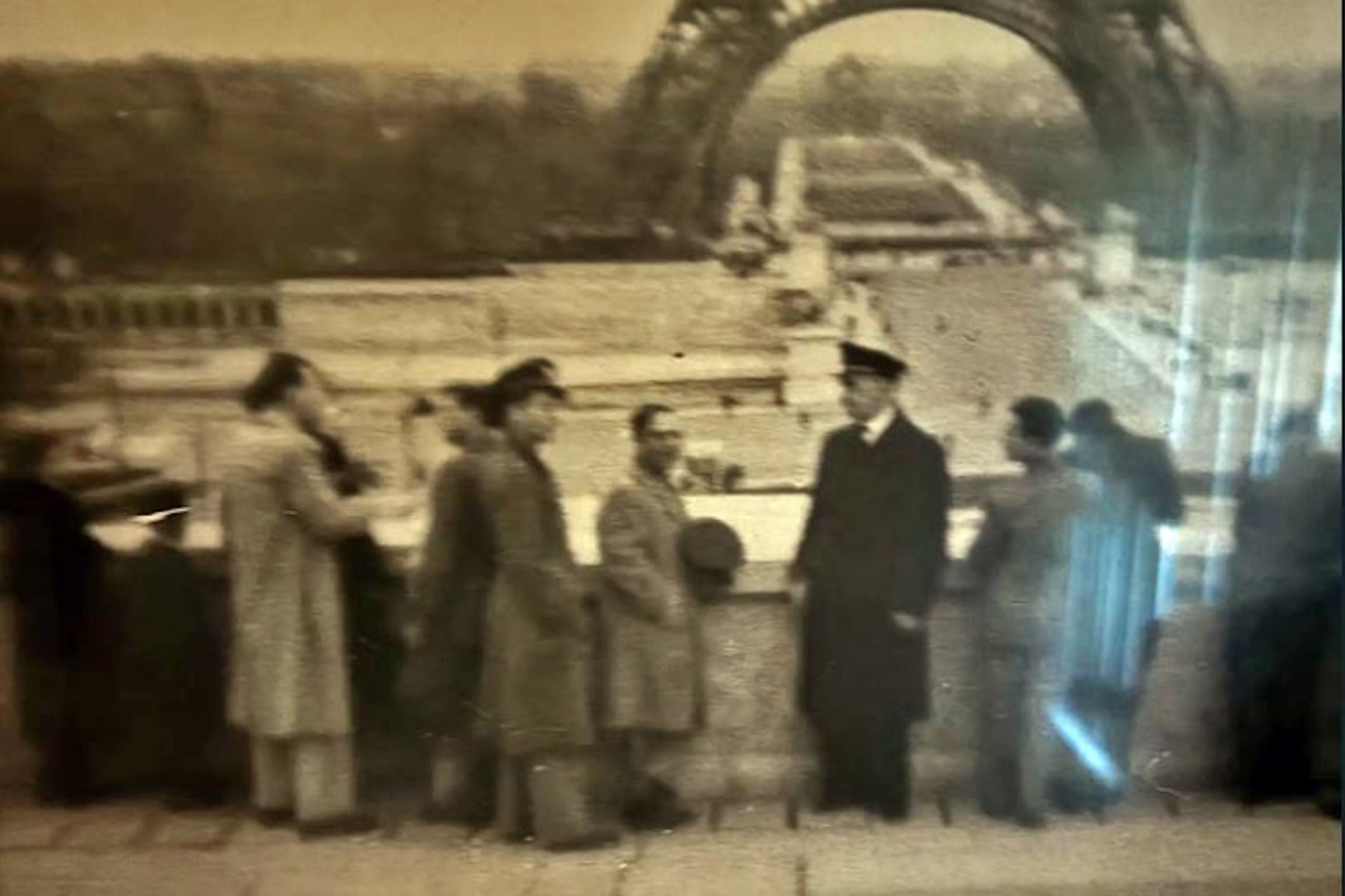 People stand in front of the Eiffel Tower in Paris.